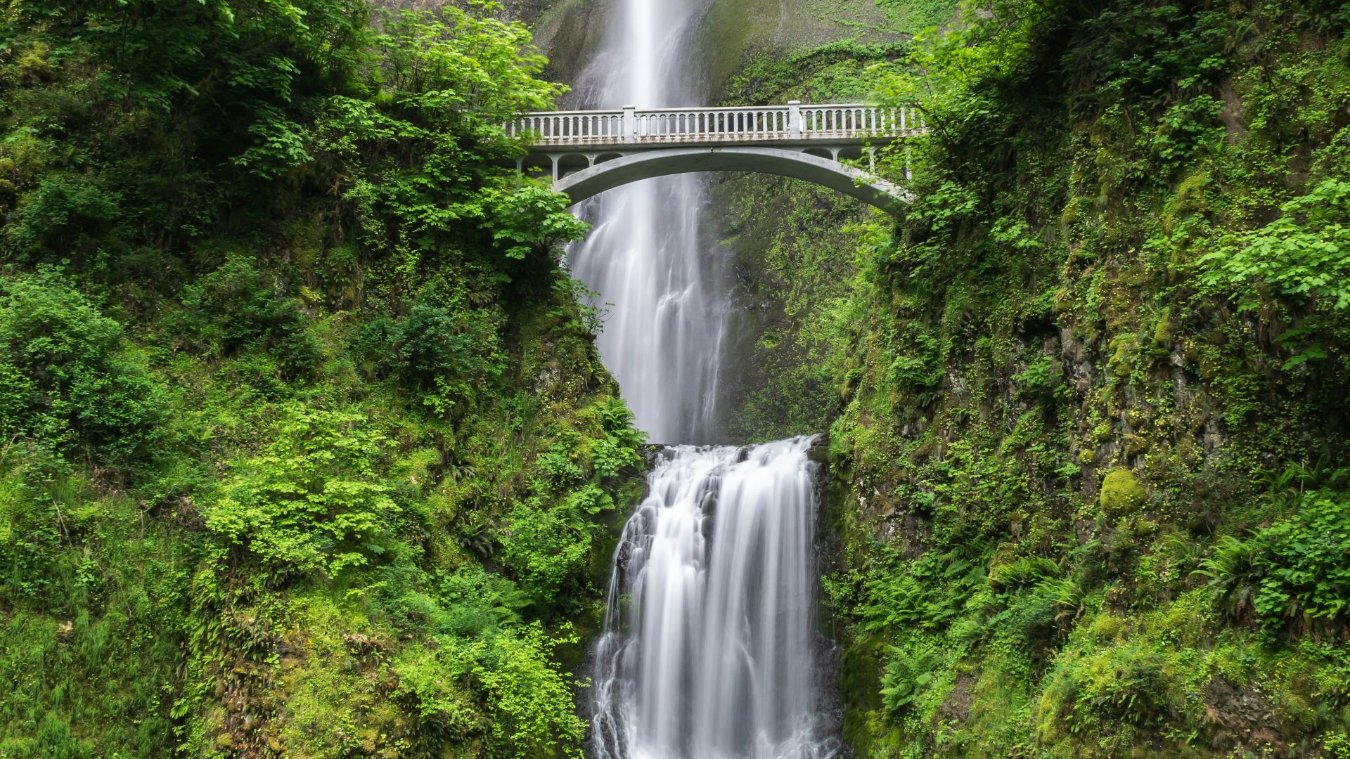 gray concrete bridge and waterfalls during daytime