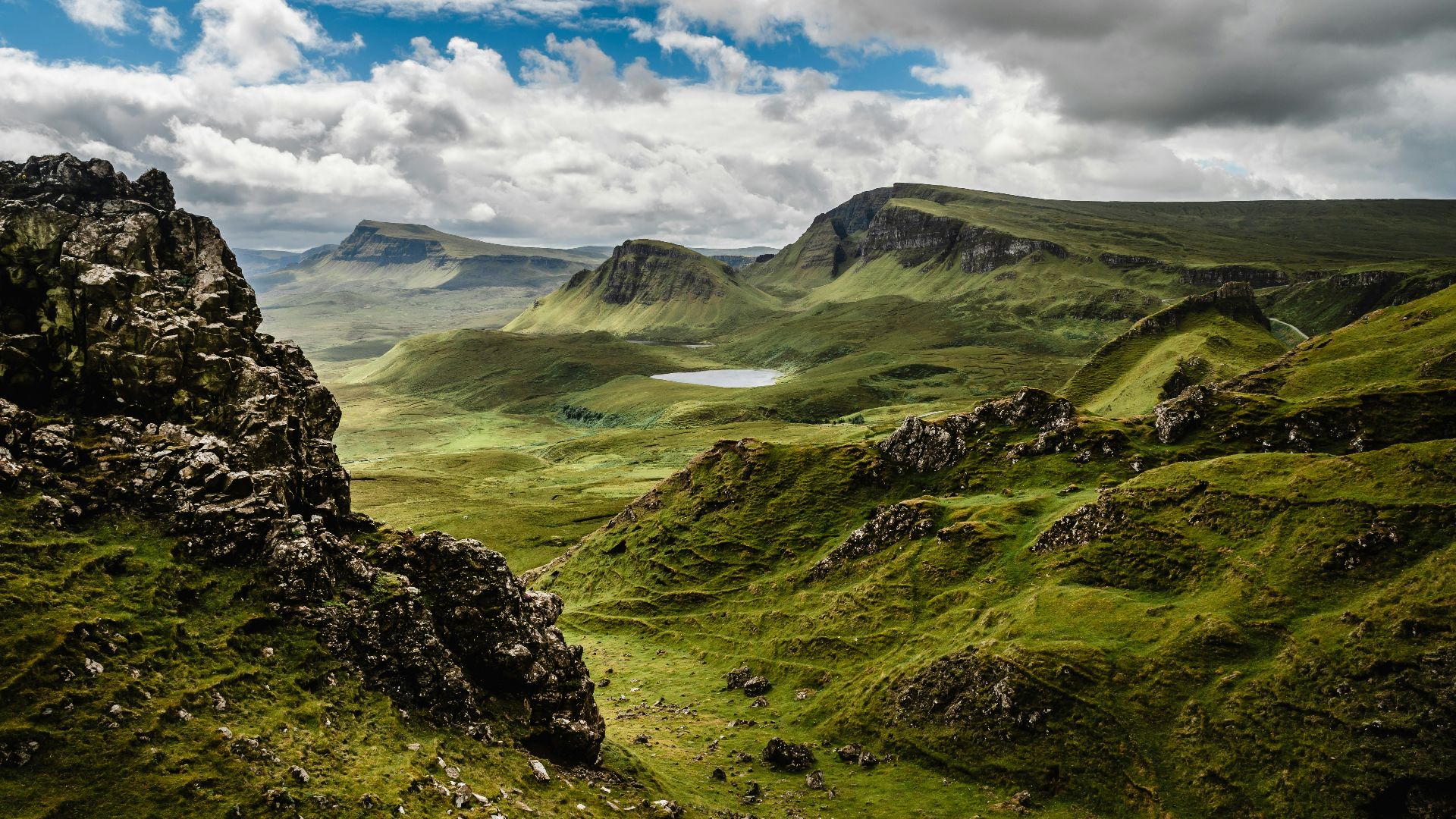 green grass on mountain under white cloudy sky