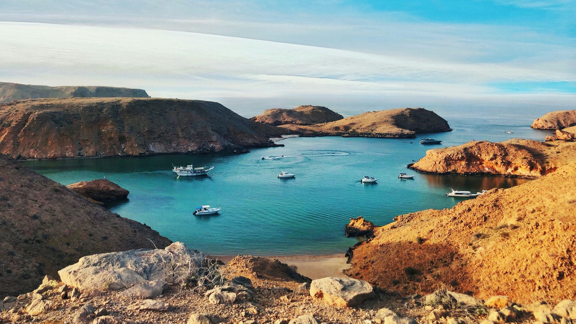 brown and green rock formation on blue sea under blue sky during daytime