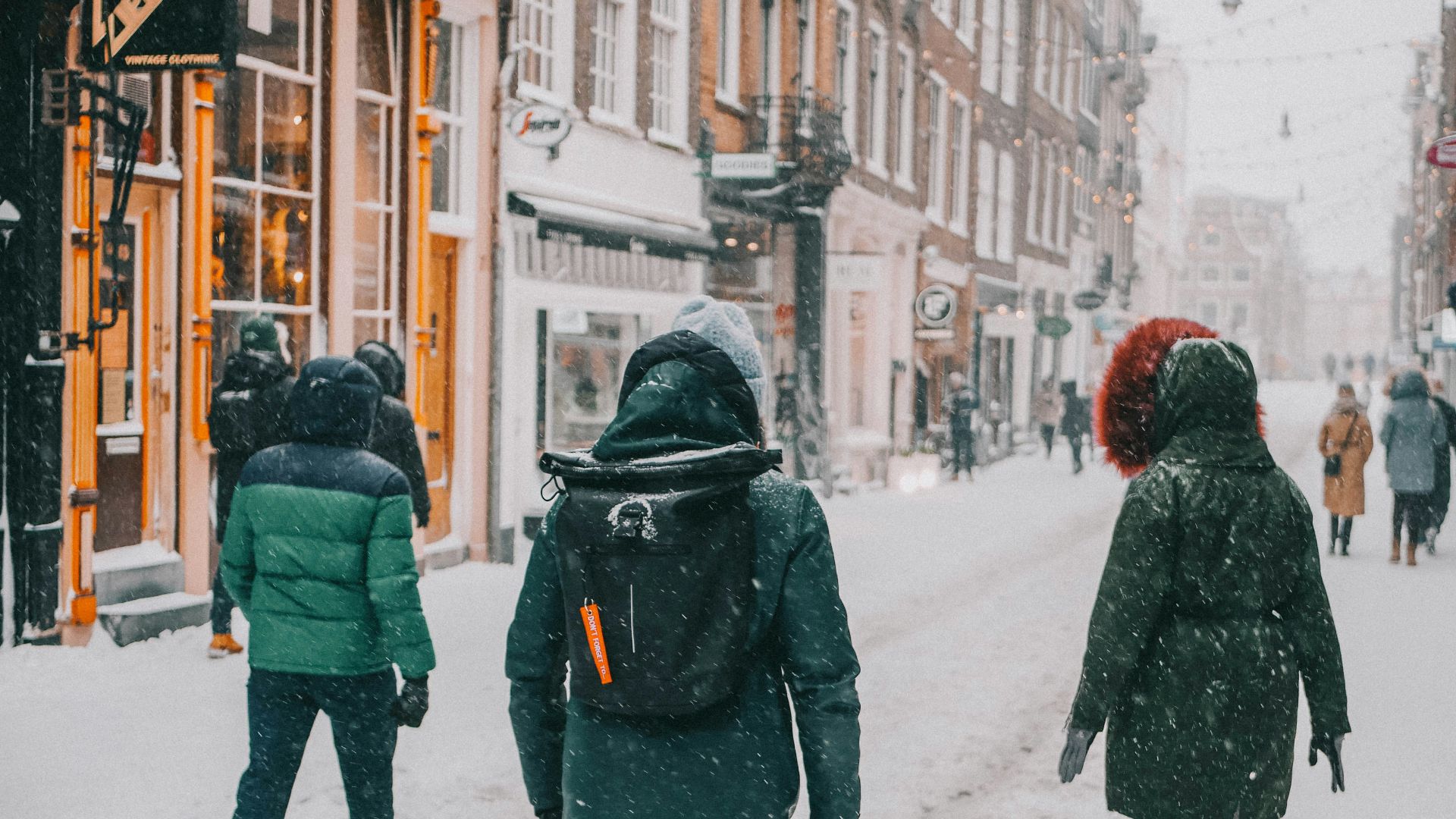 a group of people walking down a snow covered street