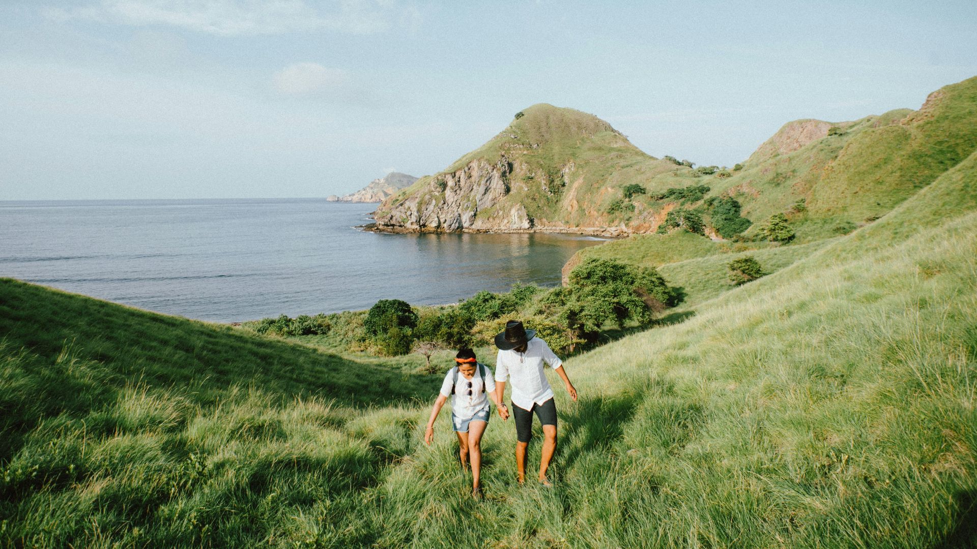 landscape photo of couple walking on green grass
