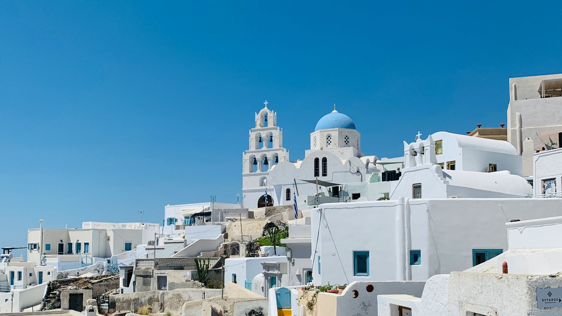 a view of a white village with a tree in the foreground