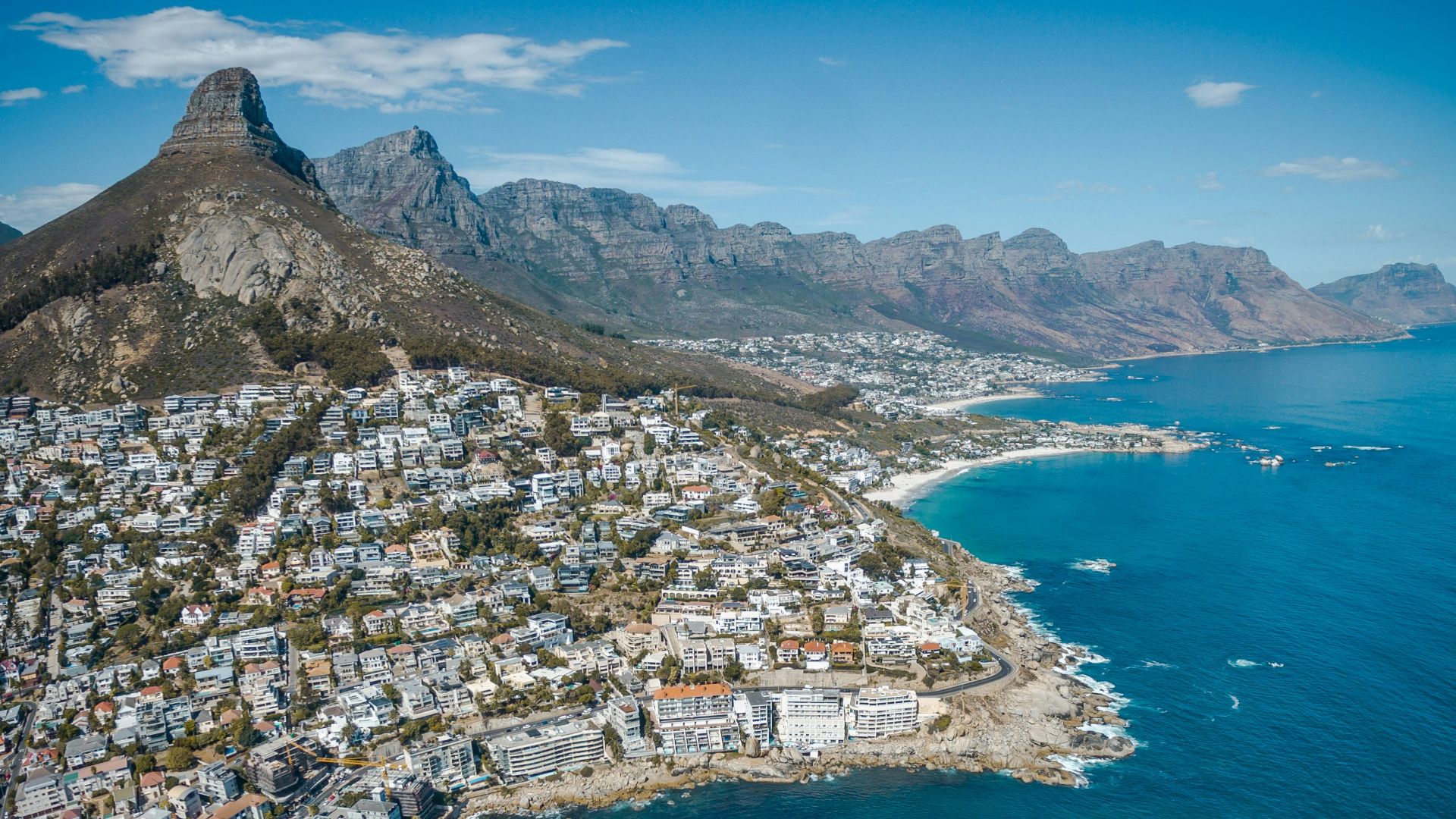 city beside body of water and mountains