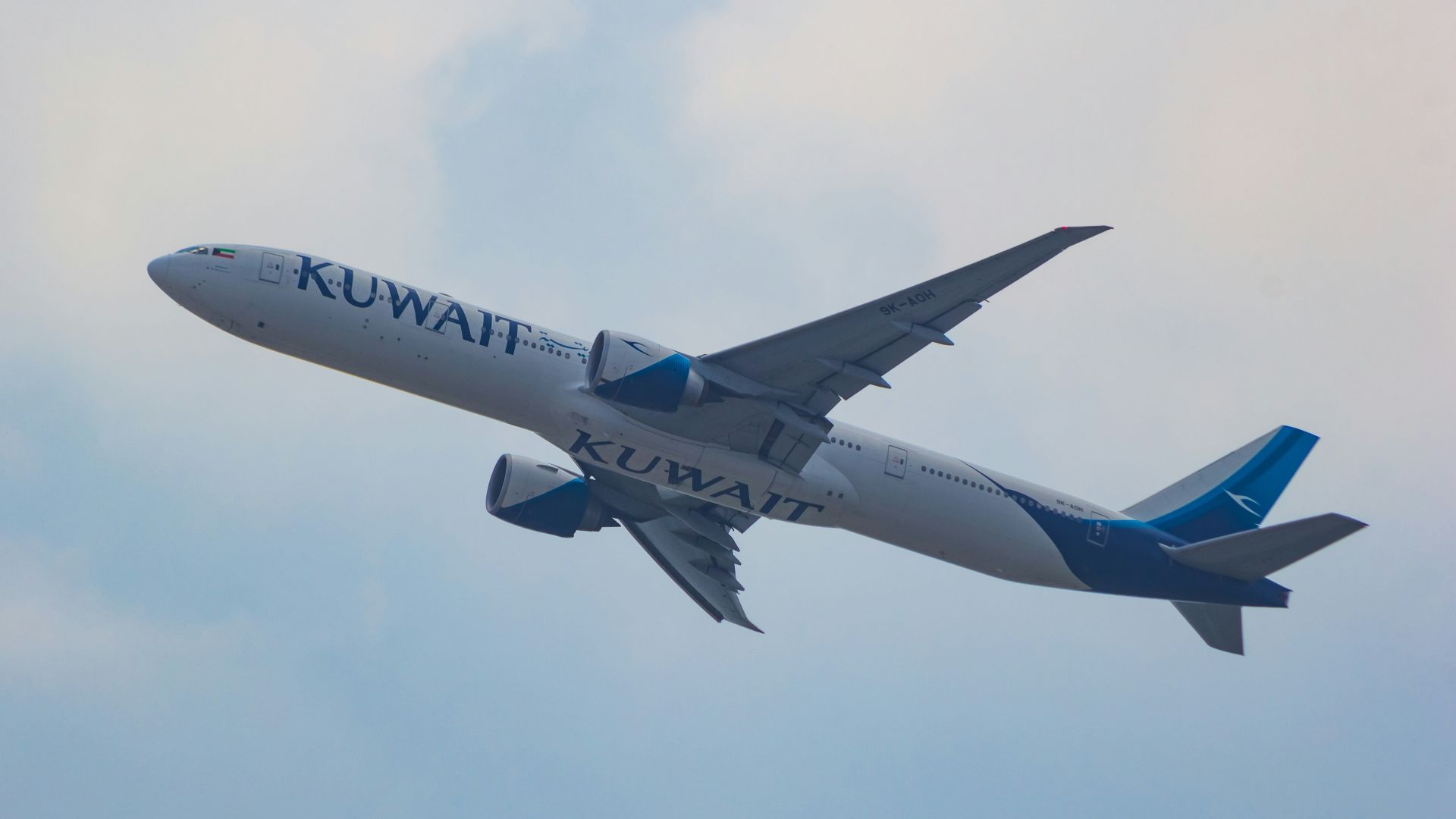 a large jetliner flying through a cloudy blue sky