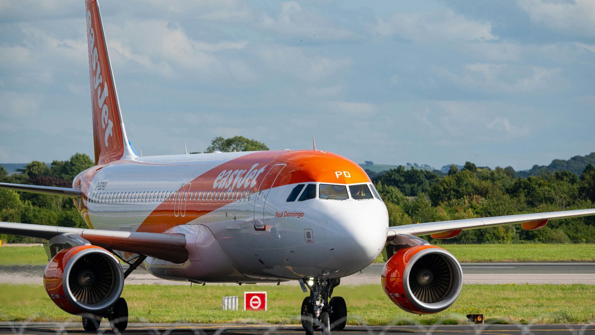 An orange and white airplane is on the runway