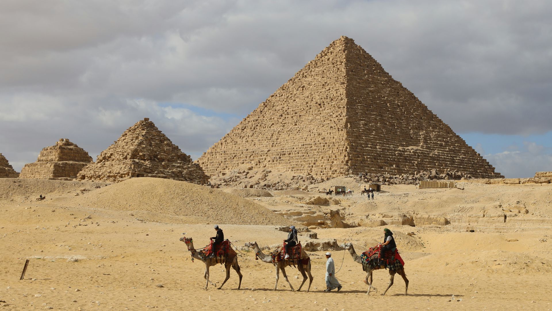 a group of people riding on the backs of camels