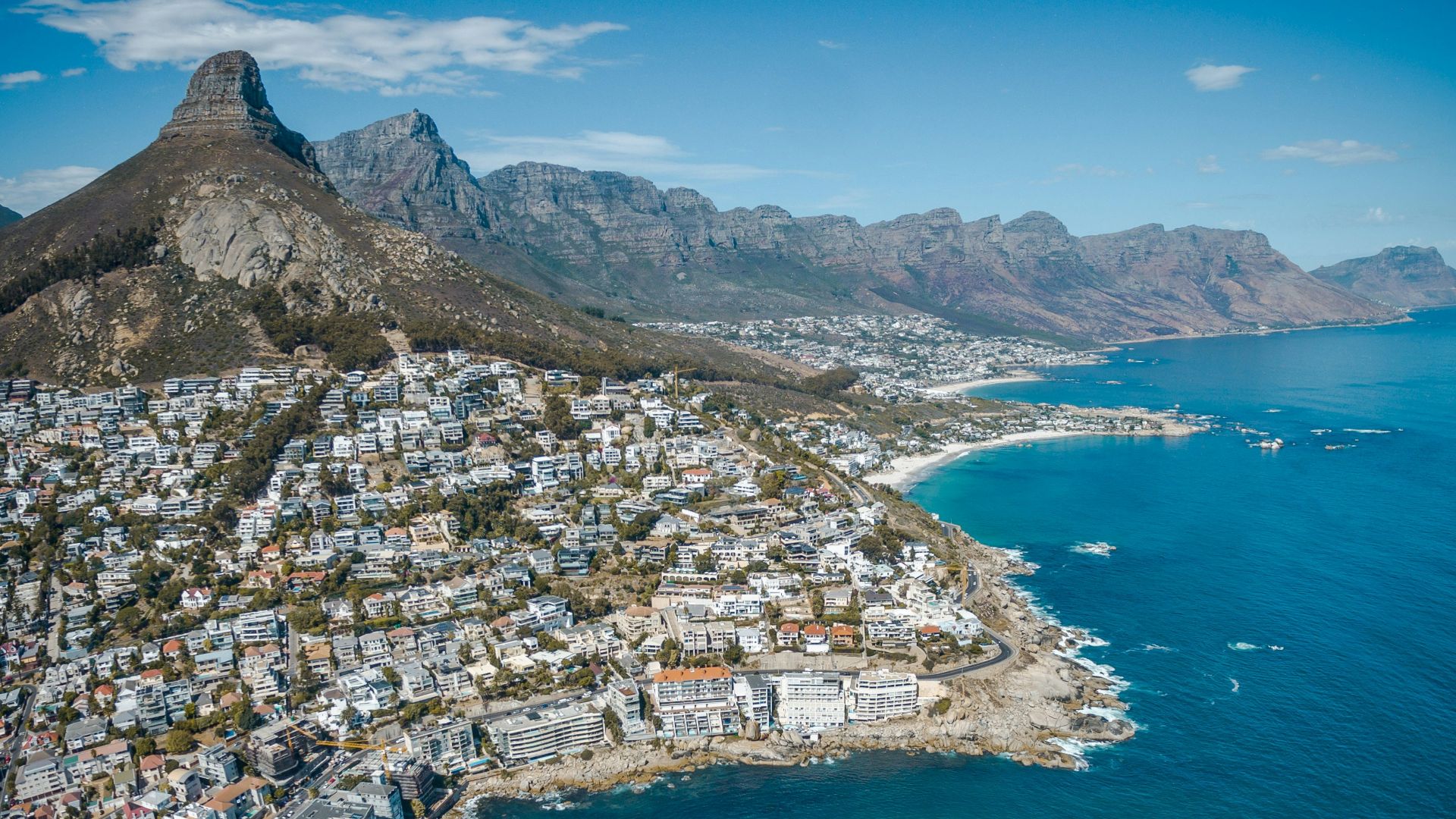 city beside body of water and mountains