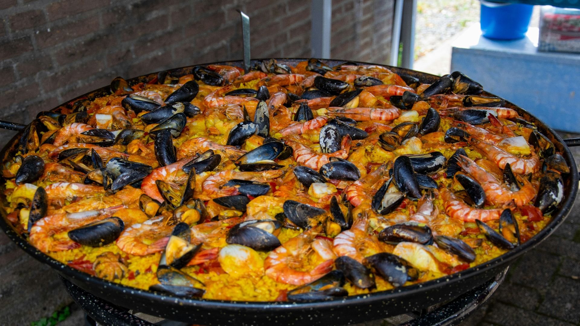 a large paella of seafood and rice on a grill