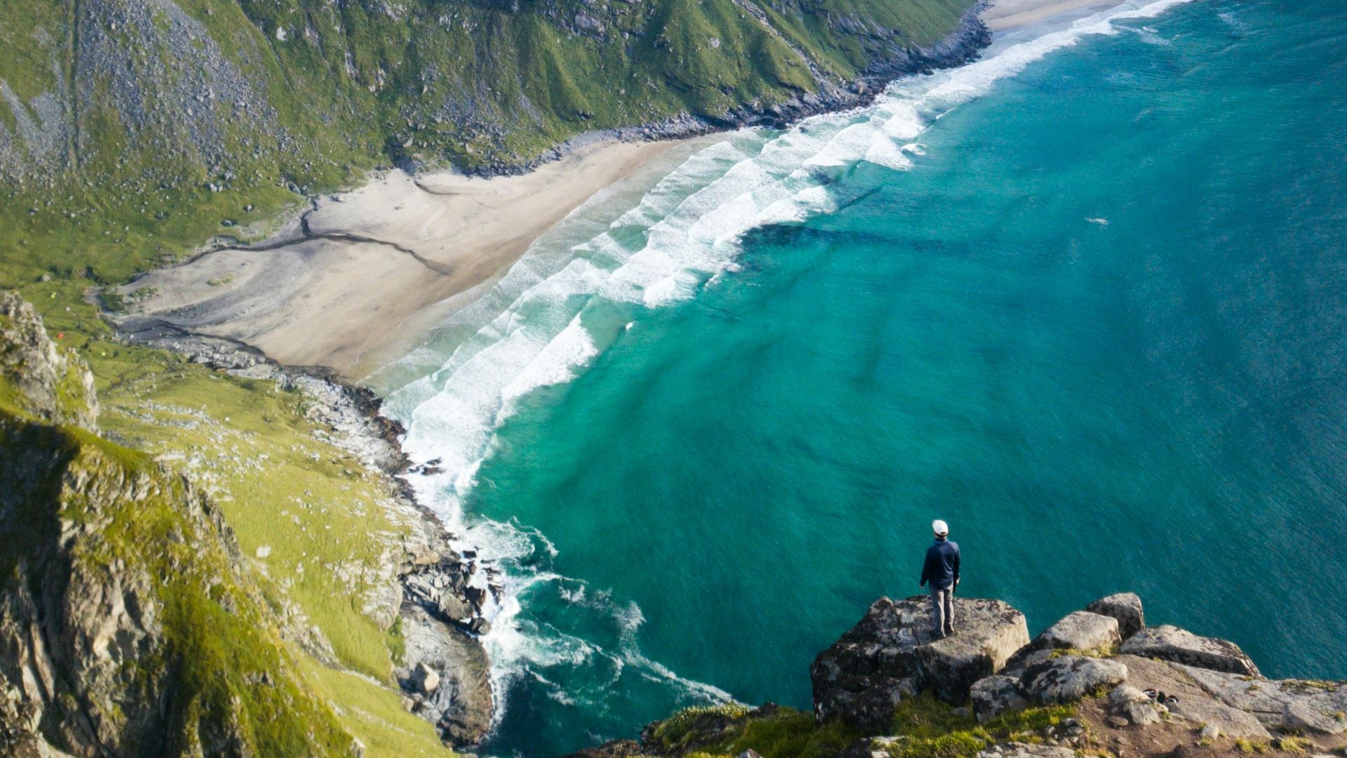 a person standing on a rocky cliff overlooking a body of water