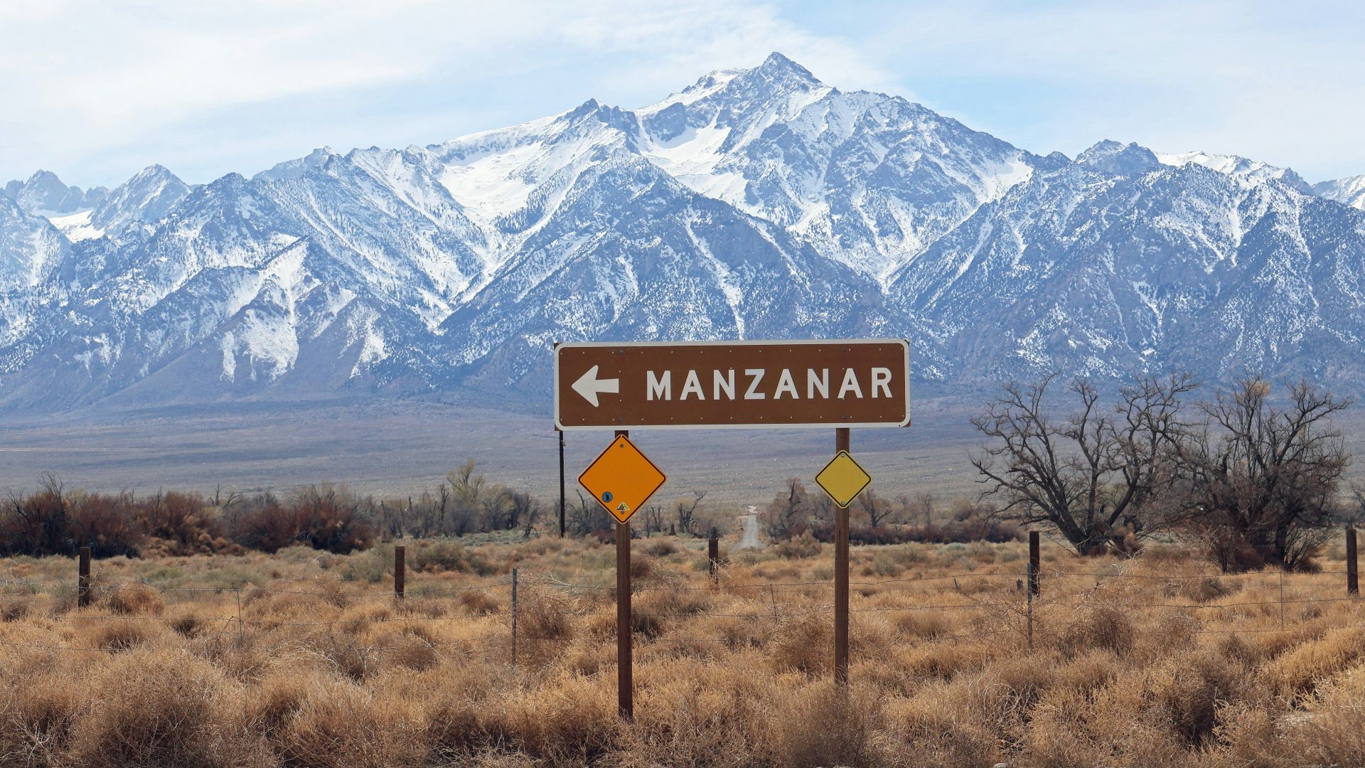 a road sign in front of a mountain range