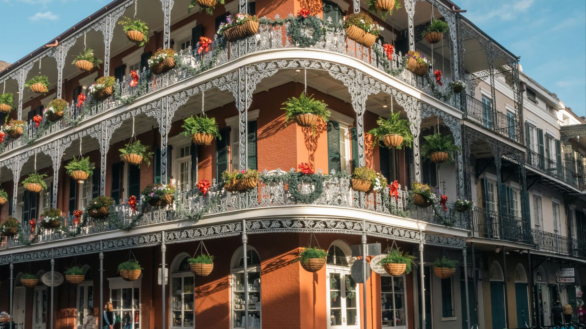 a tall building with a balcony and flowers on the balconies