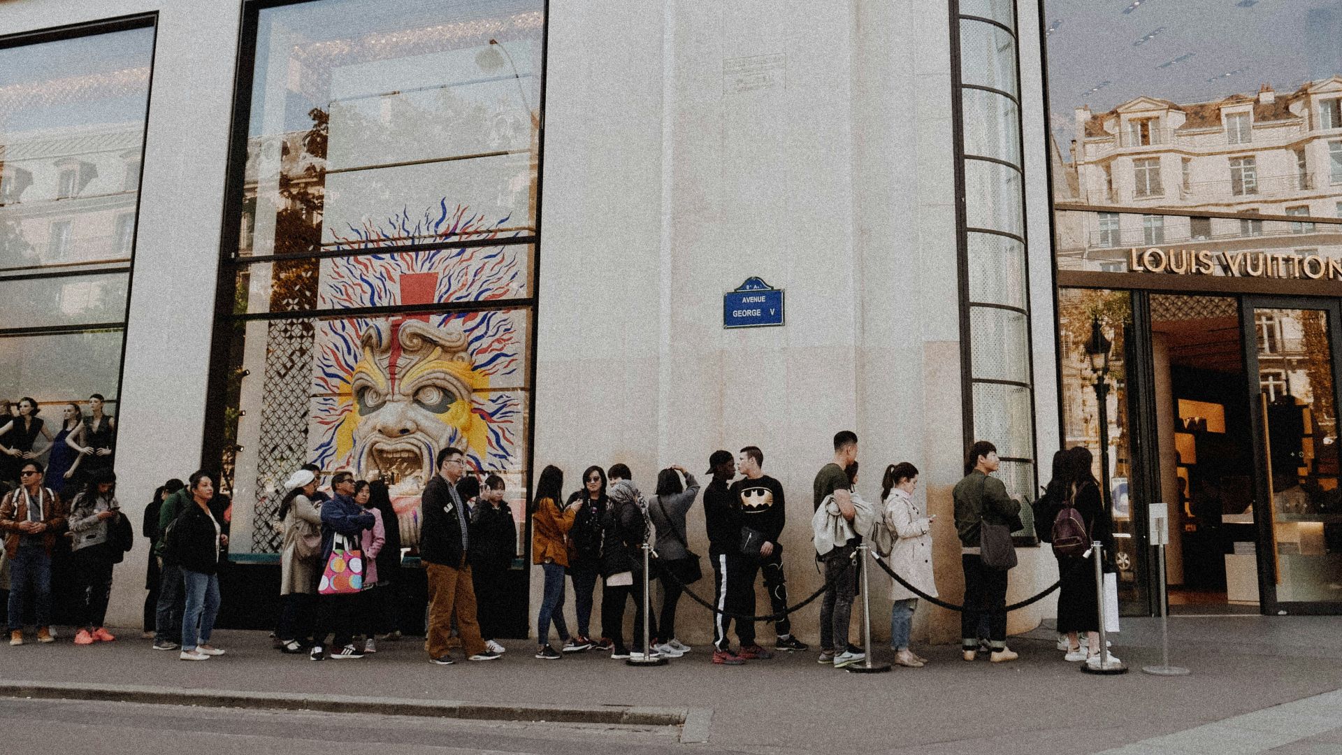 people queuing beside Louis Vuitton store