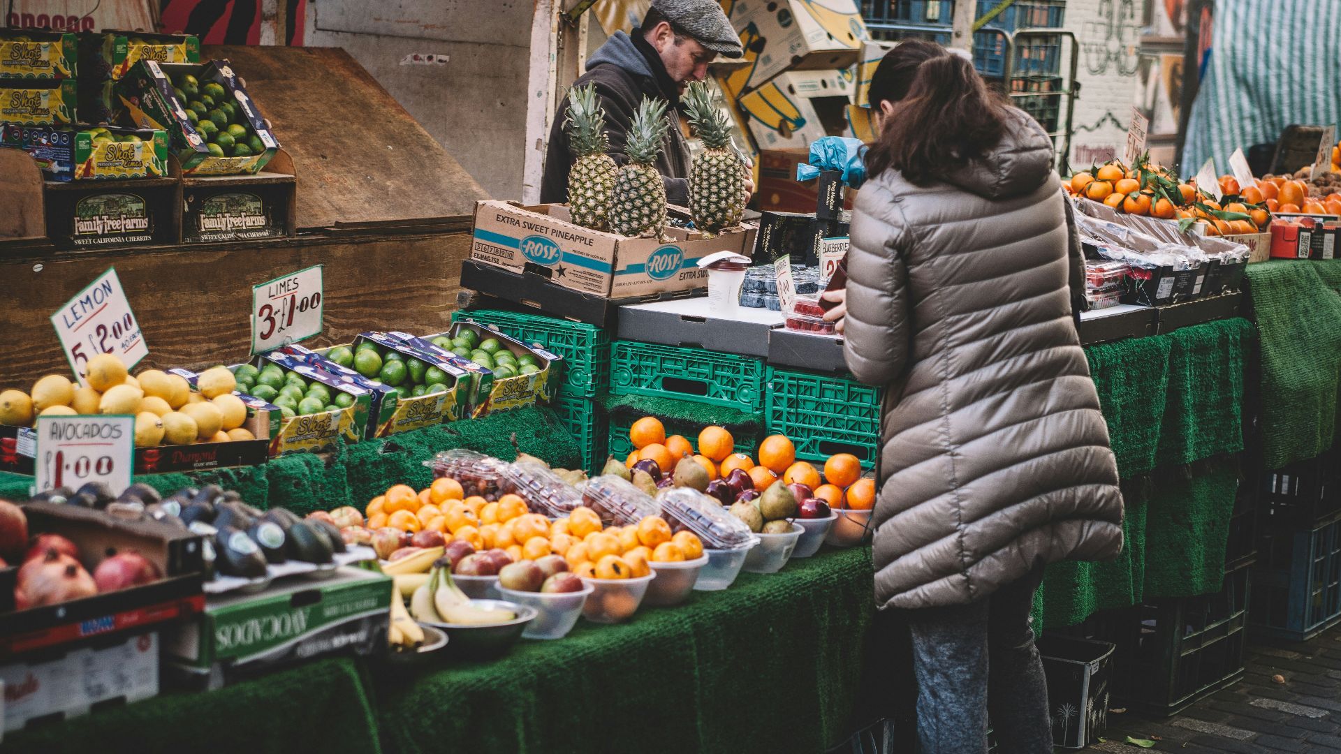 woman in front of fruit stands in market