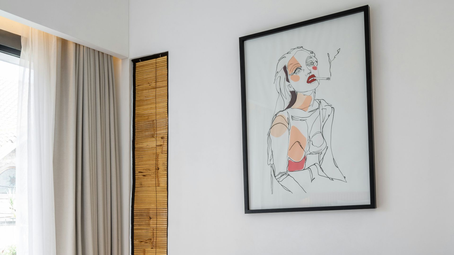 A bedroom with a white bed and a painting on the wall