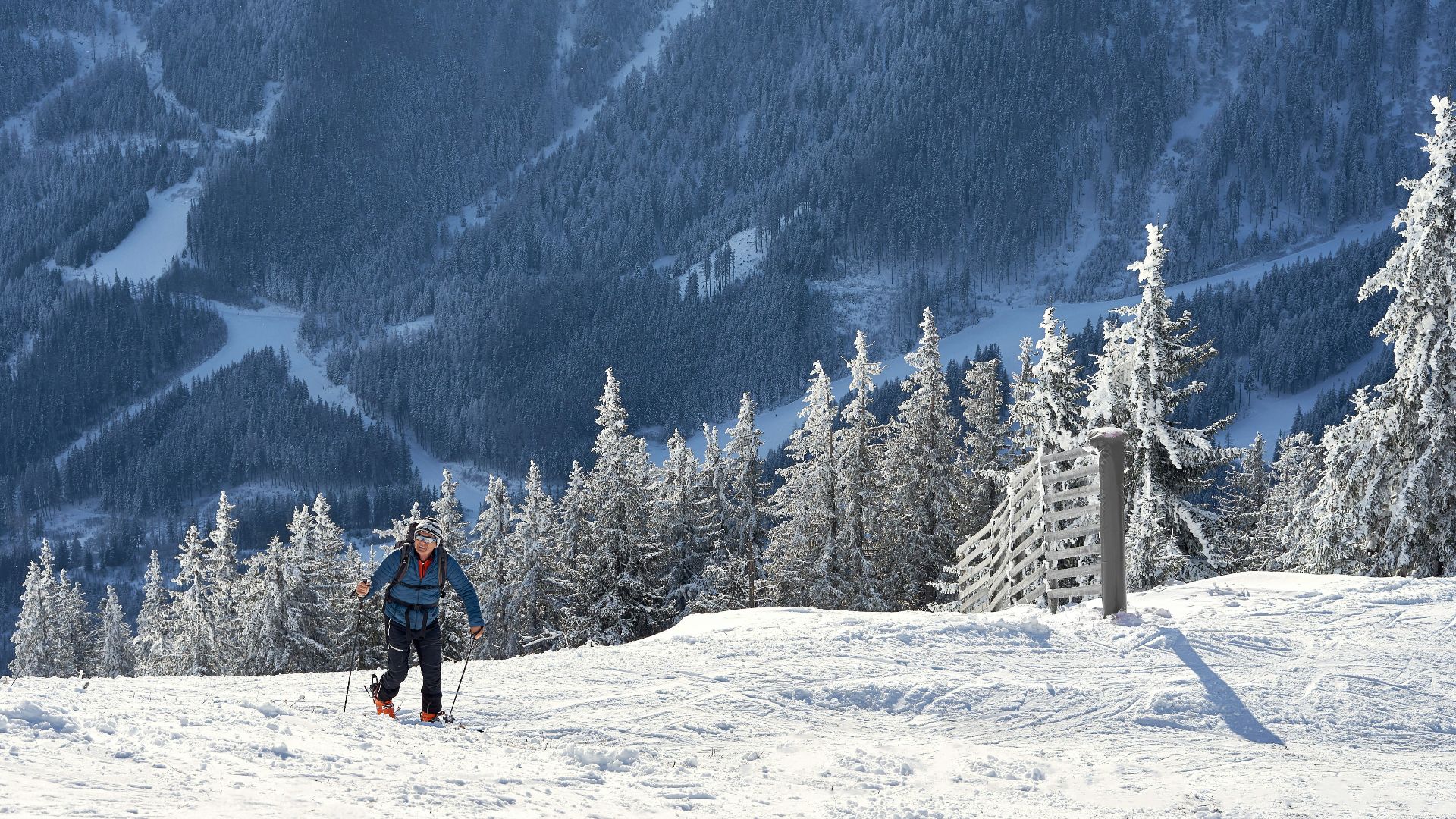 A man riding a snowboard down a snow covered slope