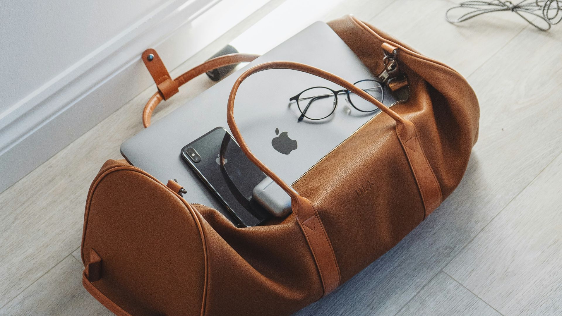 silver MacBook in duffel bag