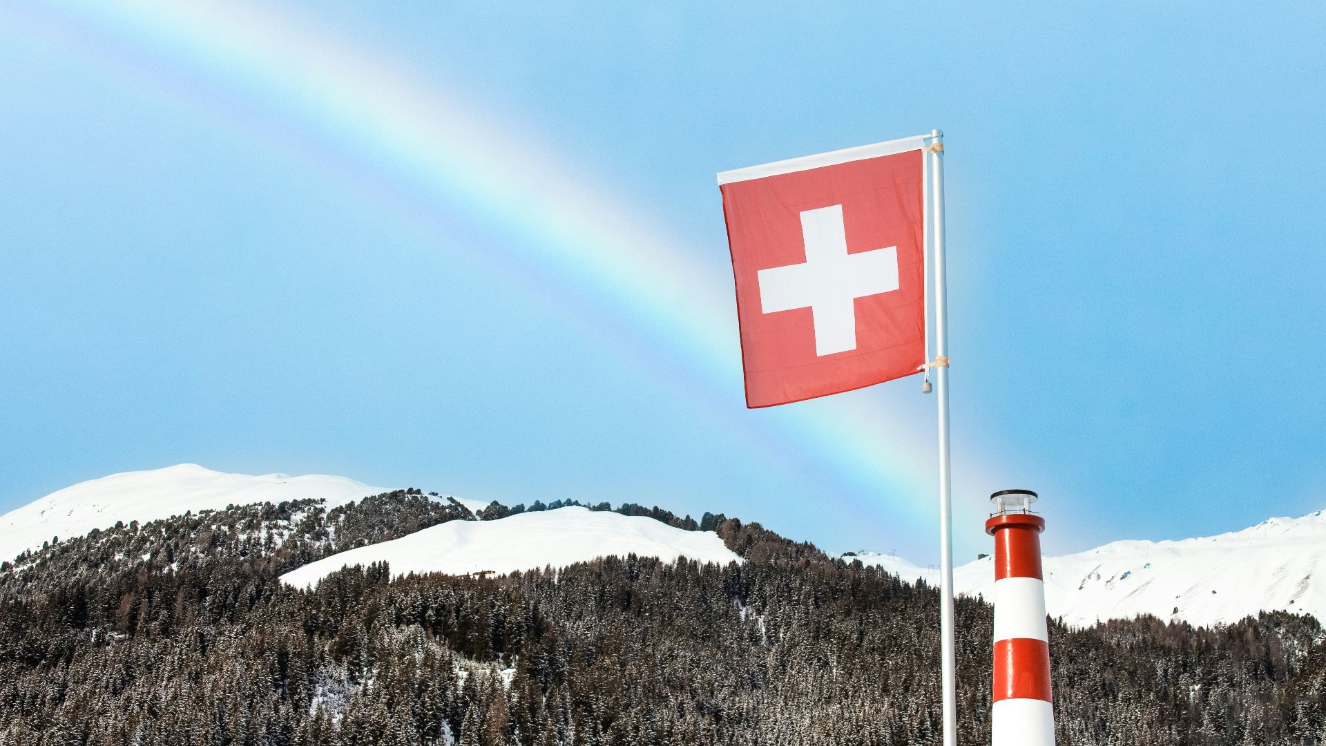 red and white cross flag on top of mountain