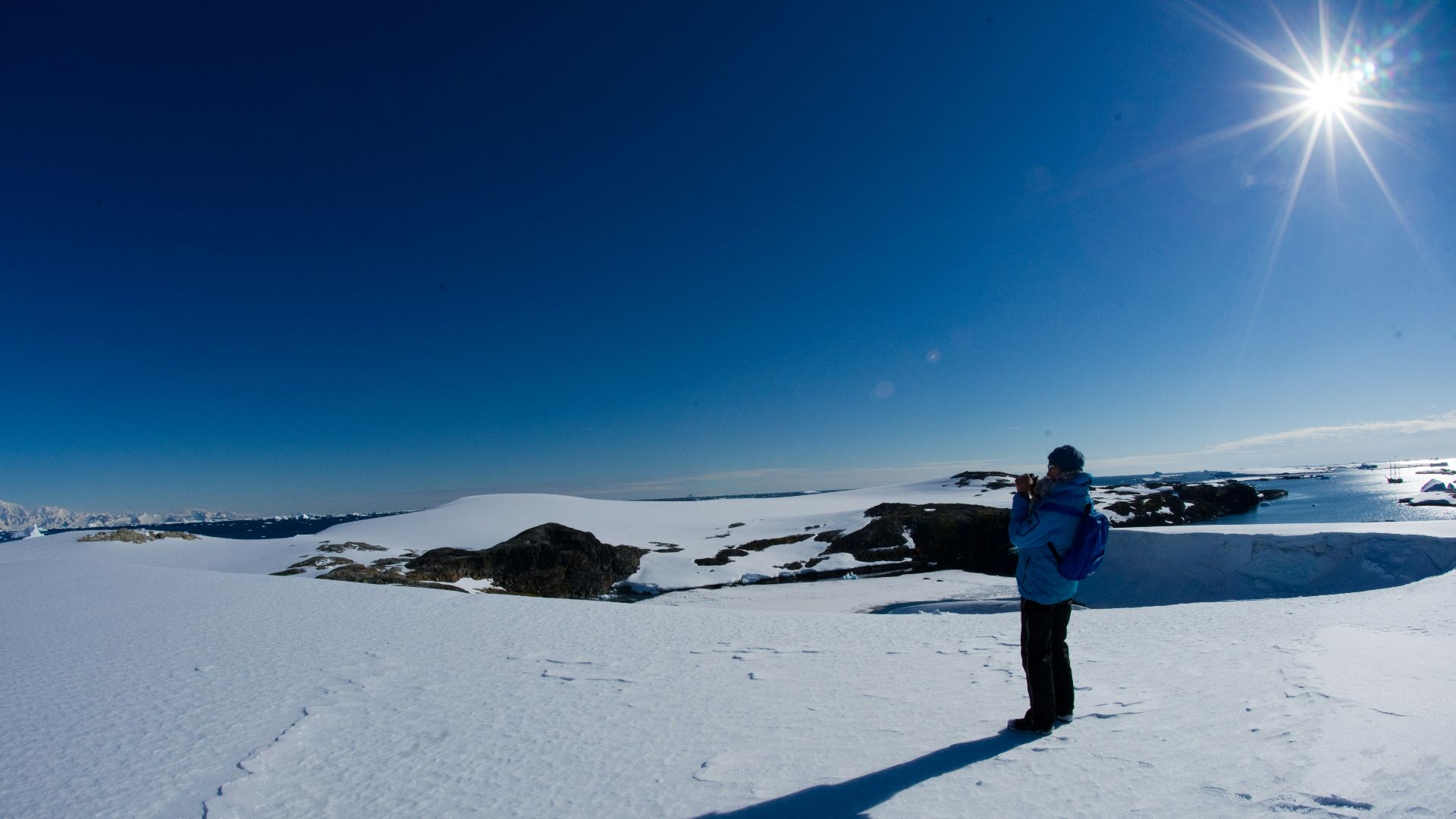 a man standing on top of a snow covered slope