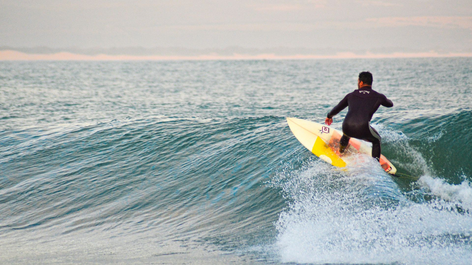 A man riding a wave on top of a surfboard