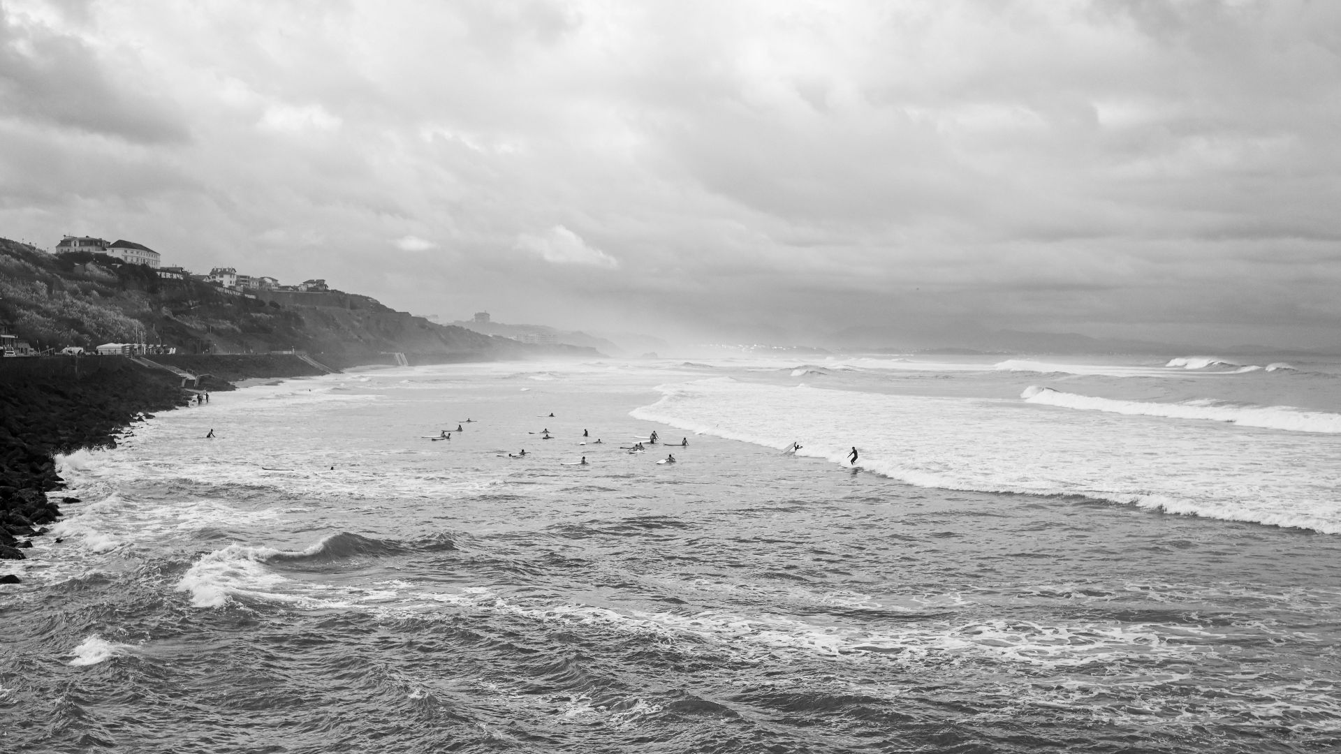 a black and white photo of surfers in the ocean