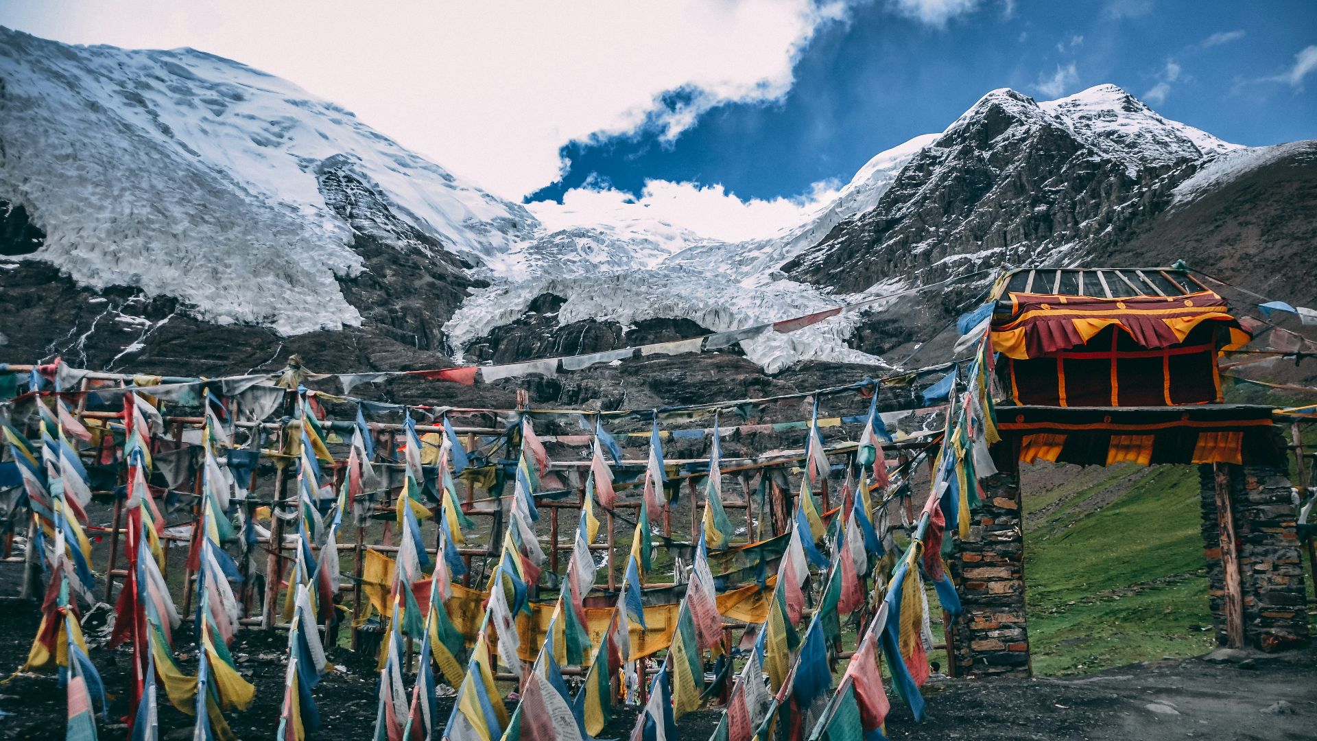 multicolored streamers near snow mountain under blue and white cloudy sky