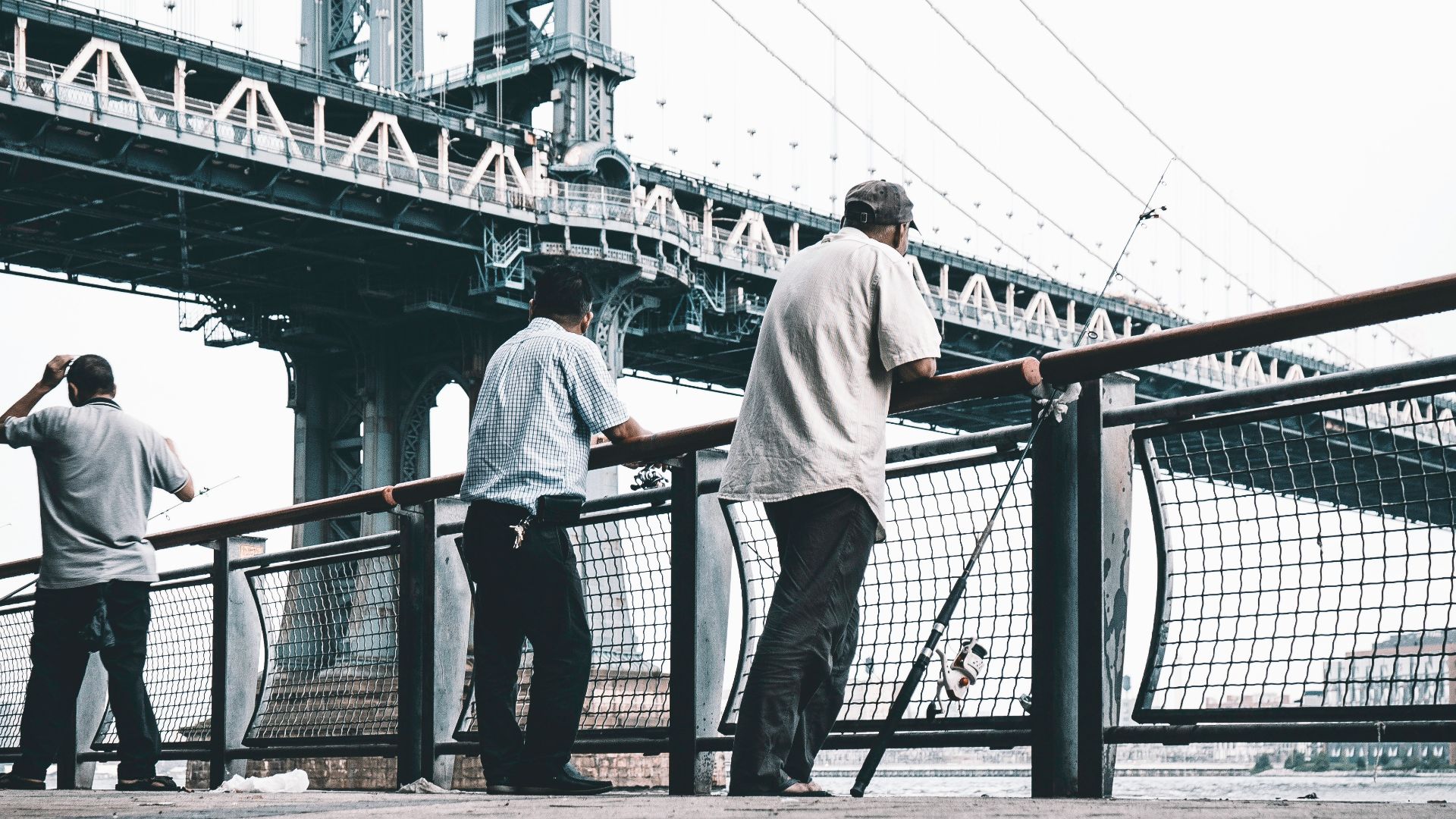 three men standing near bridge