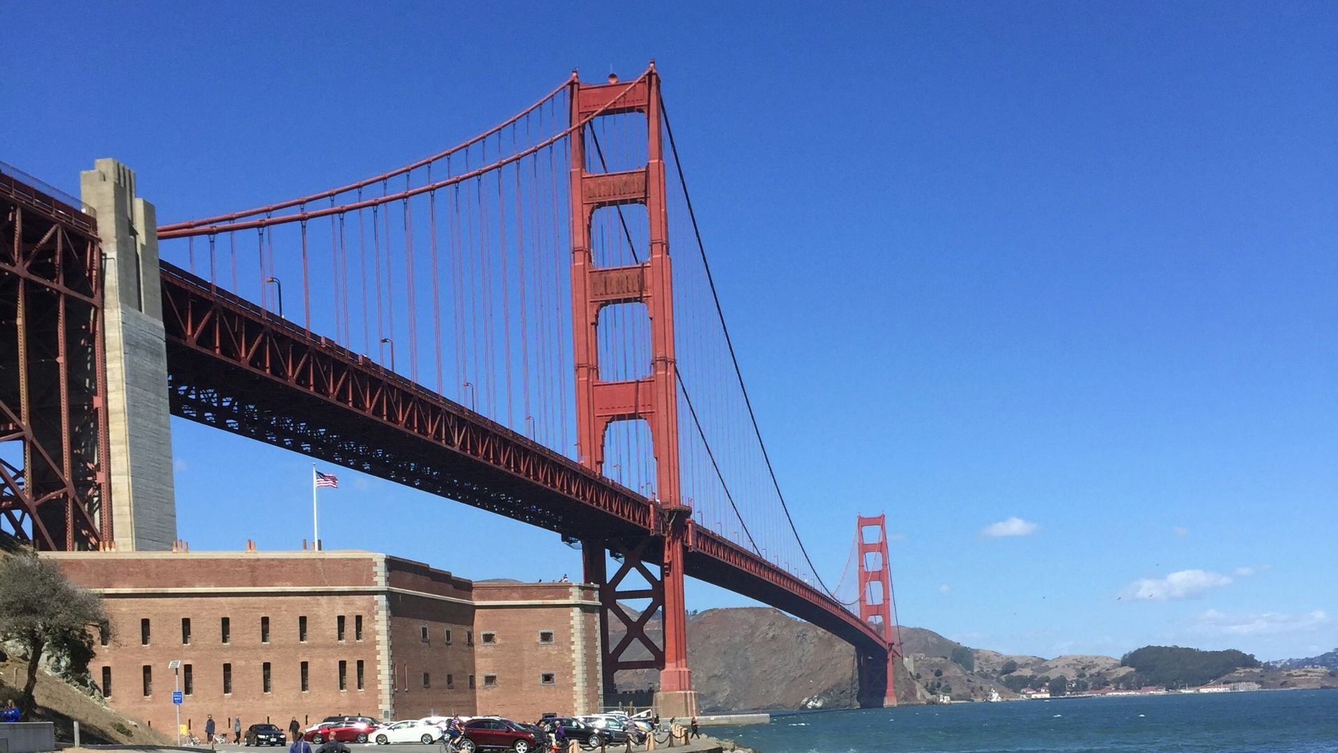 man in yellow shirt riding bicycle on bridge during daytime
