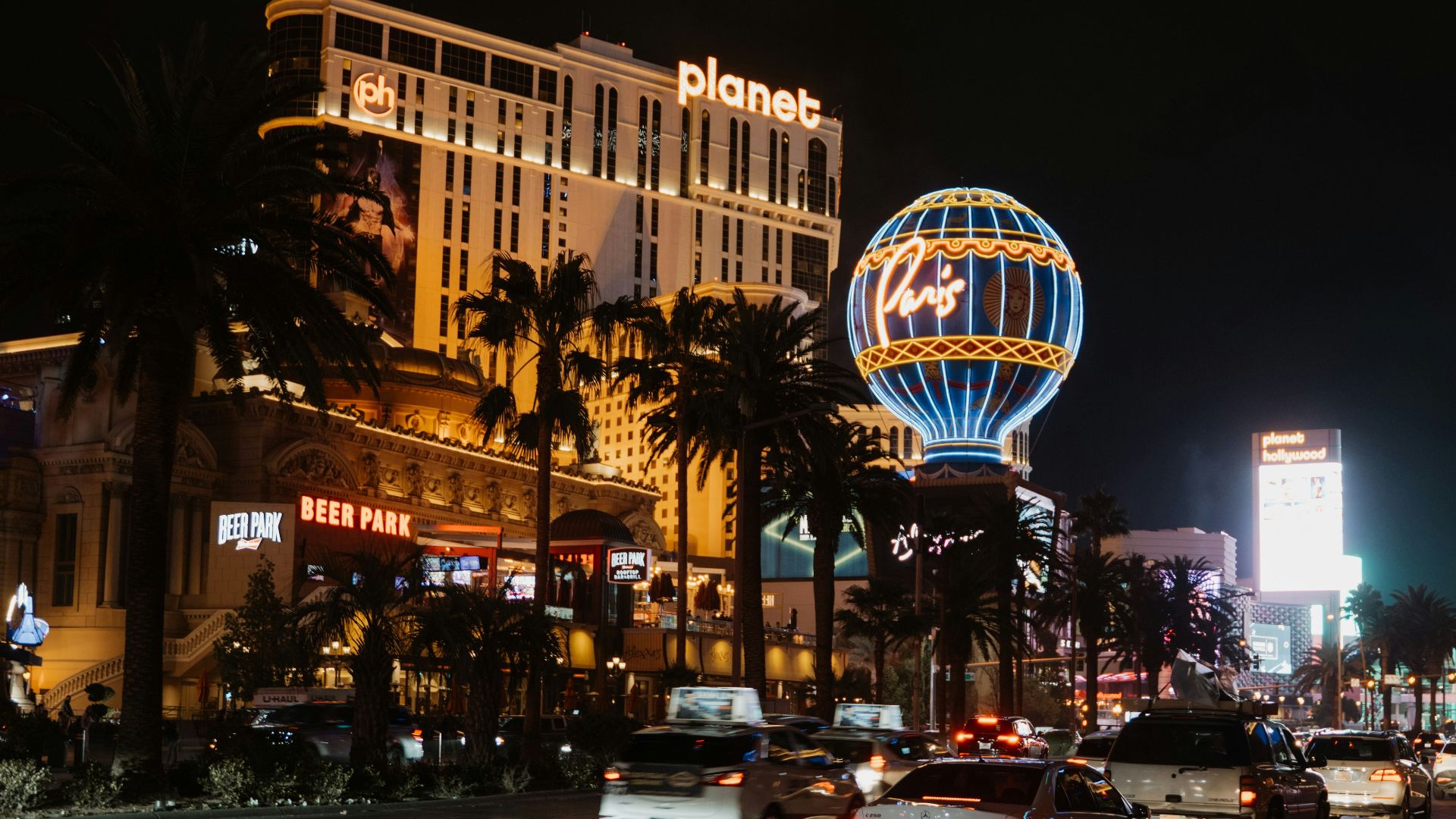 a busy city street at night with cars driving by