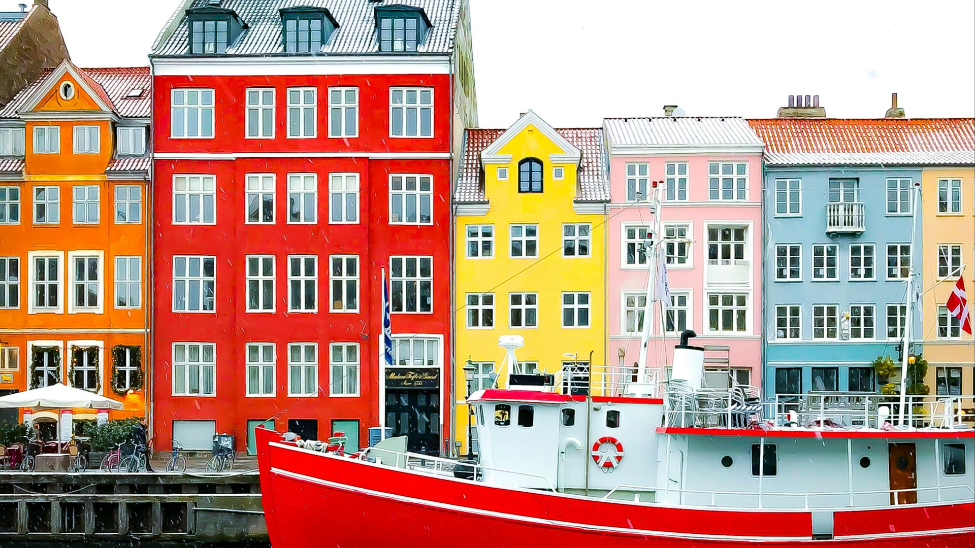 assorted-color buildings near red boat docked on port during daytime