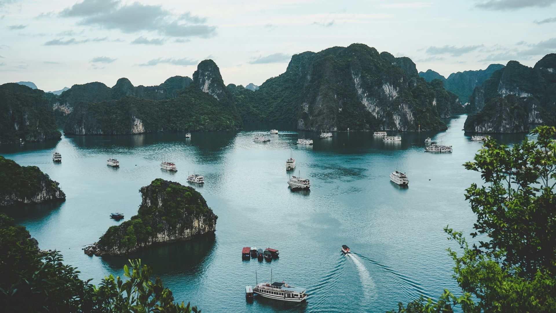 high-angle photography of boats on water near hill during daytime