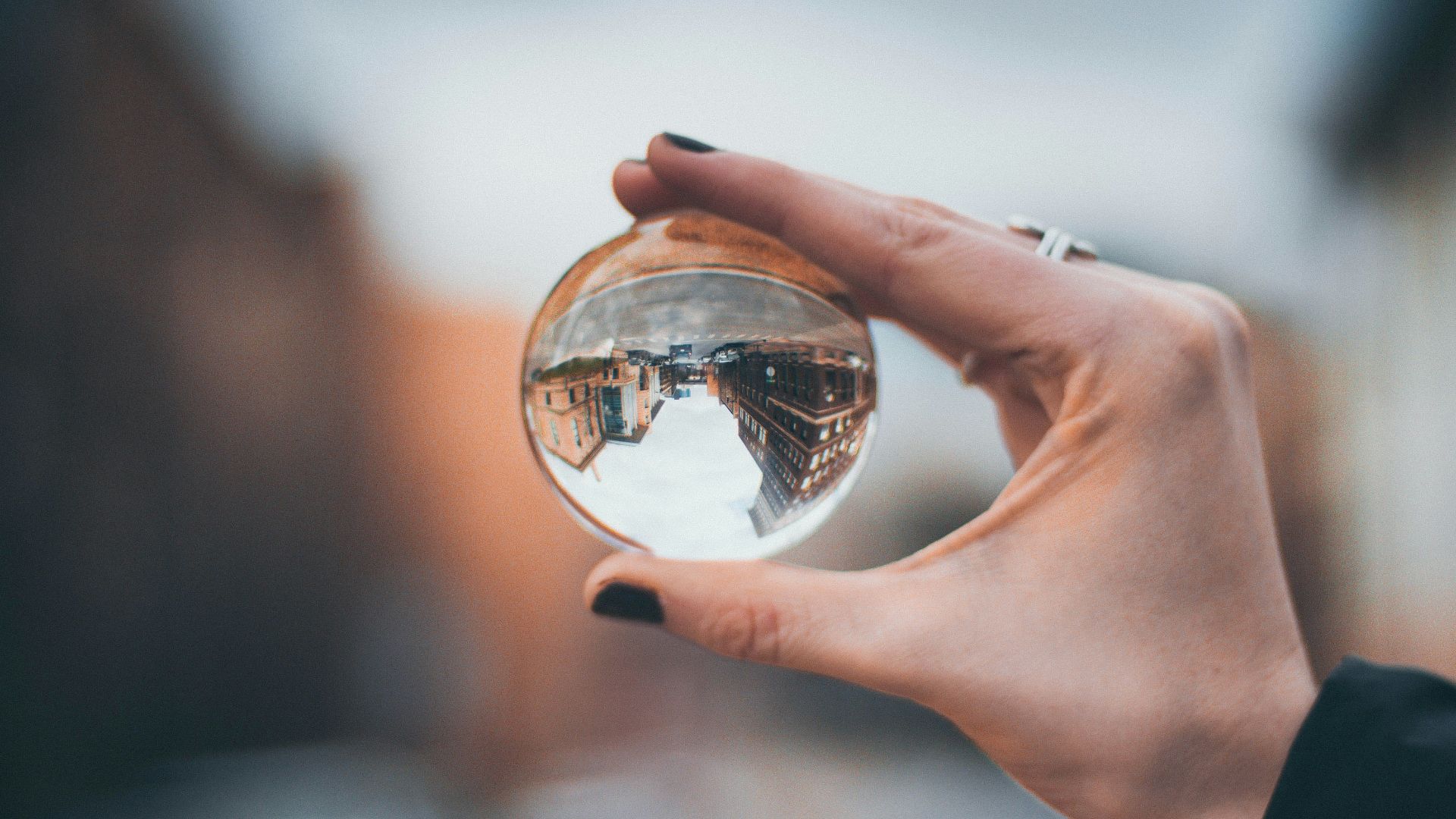selective focus photography of woman holding clear glass ball