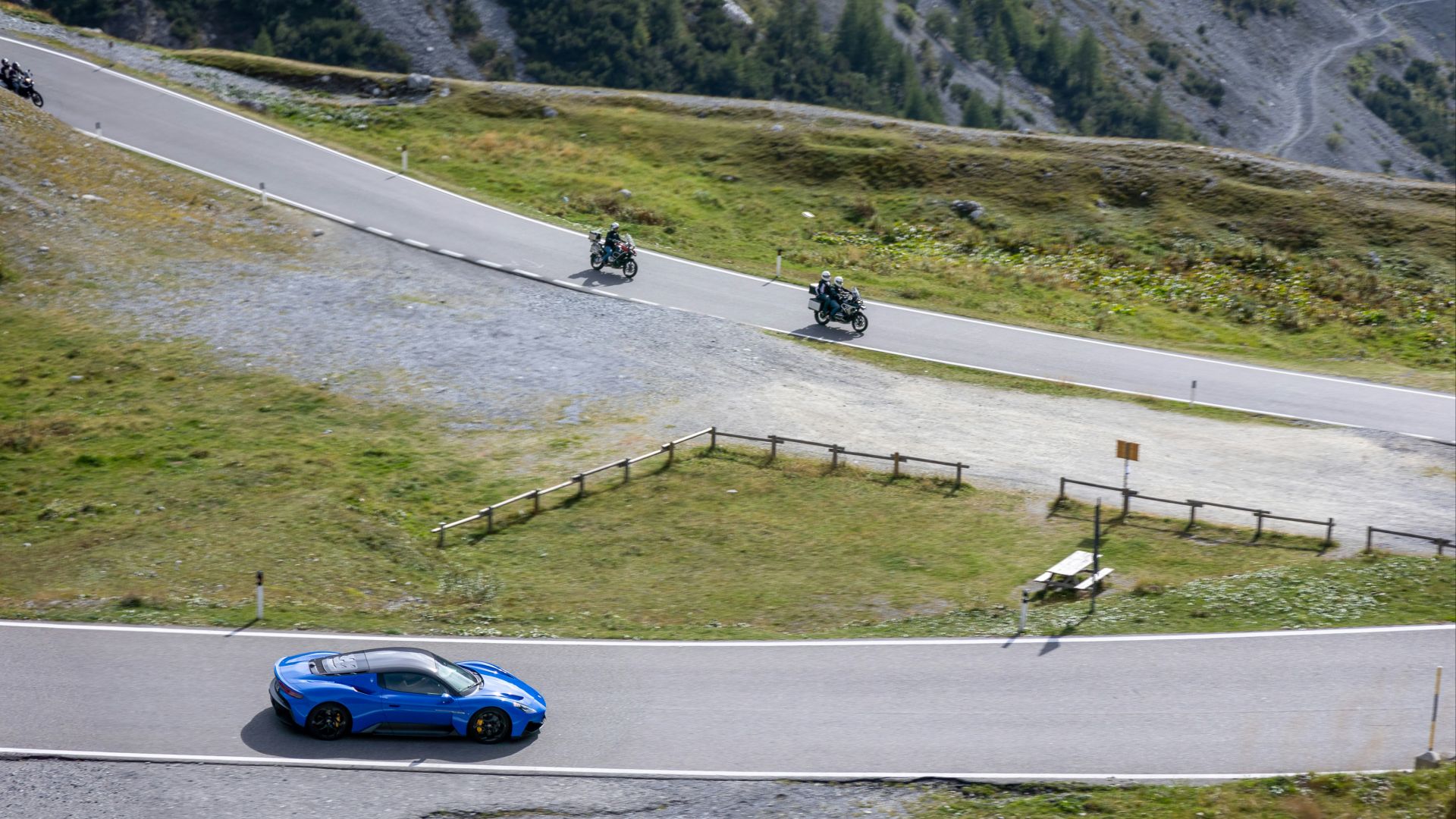 a blue car driving down a winding road
