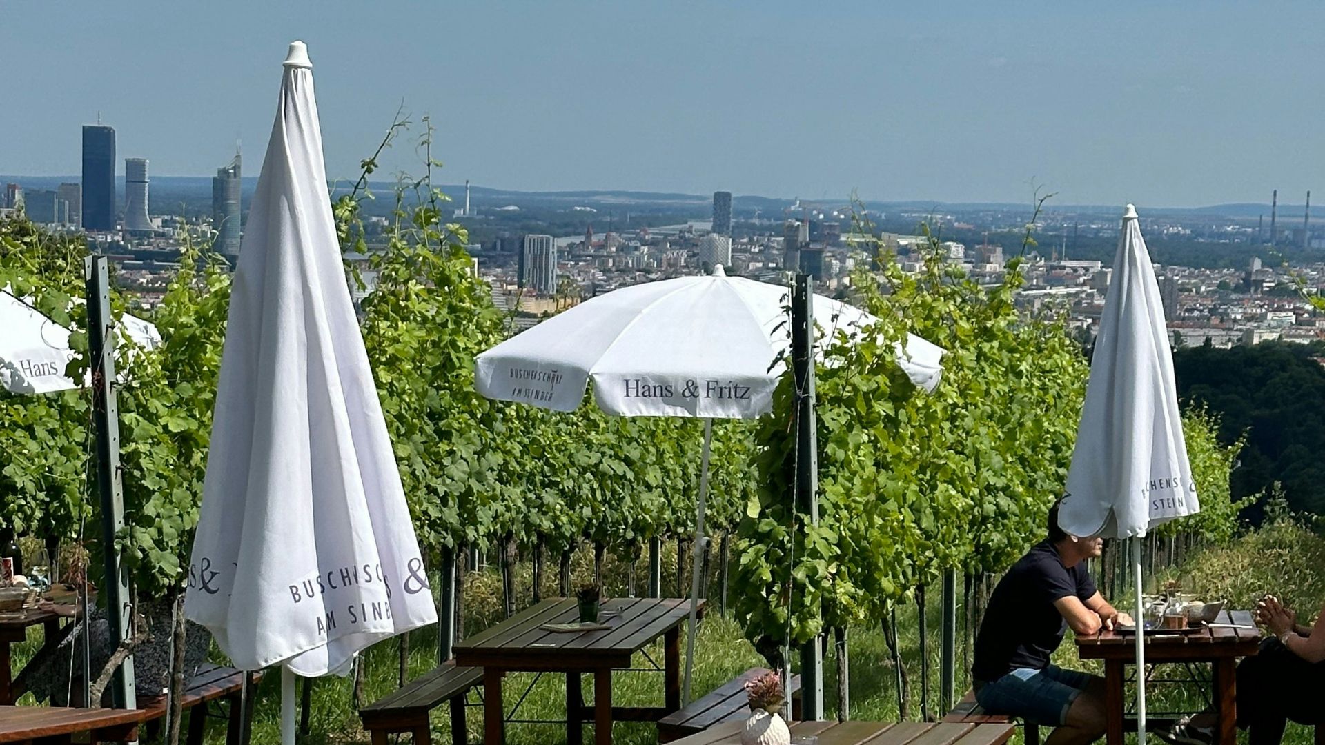 A bunch of tables and umbrellas in a field