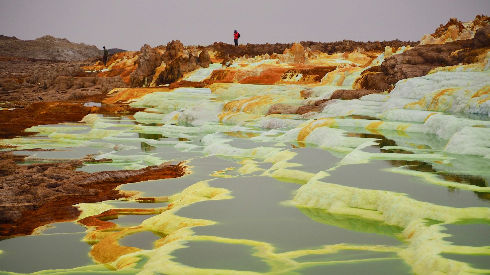 two people standing on top of hill