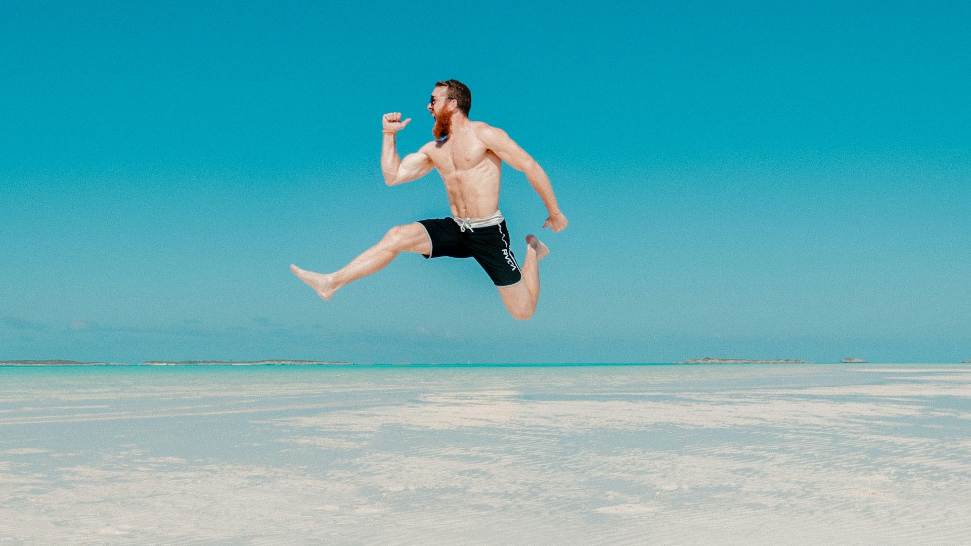 time lapse photography of man jumping at seashore