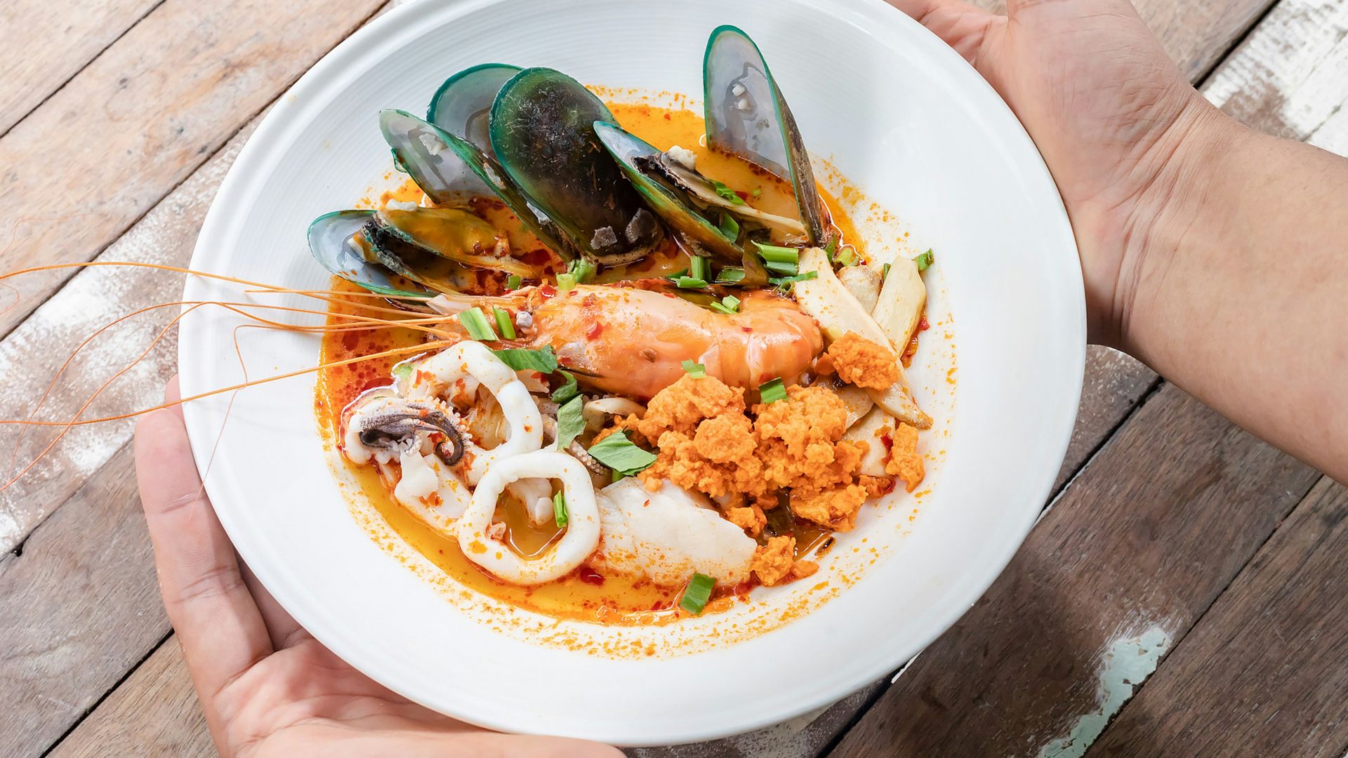person holding white ceramic plate with food