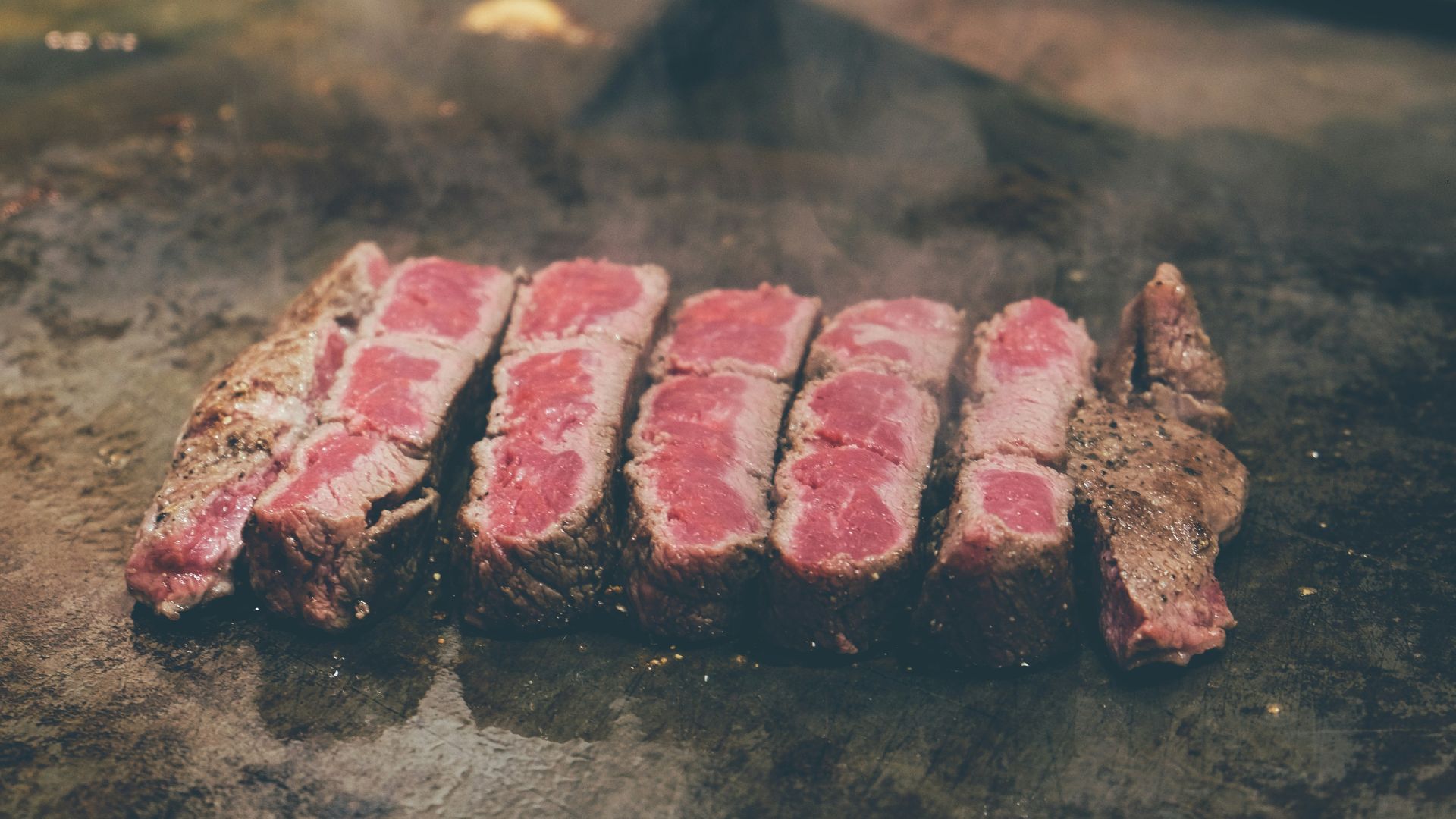 sliced meat on black surface