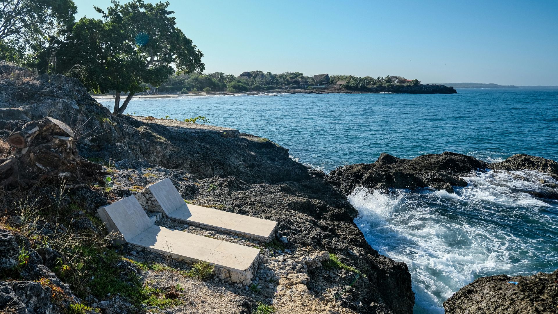 a couple of chairs sitting on top of a rocky beach