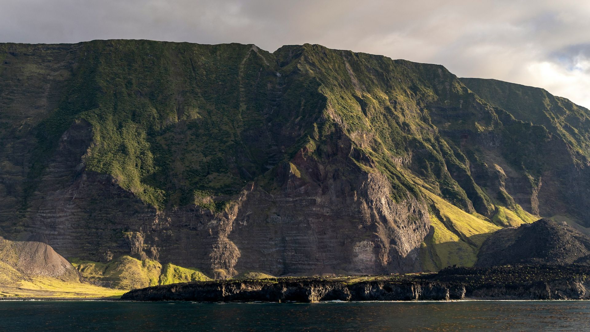 a large mountain with a body of water in front of it