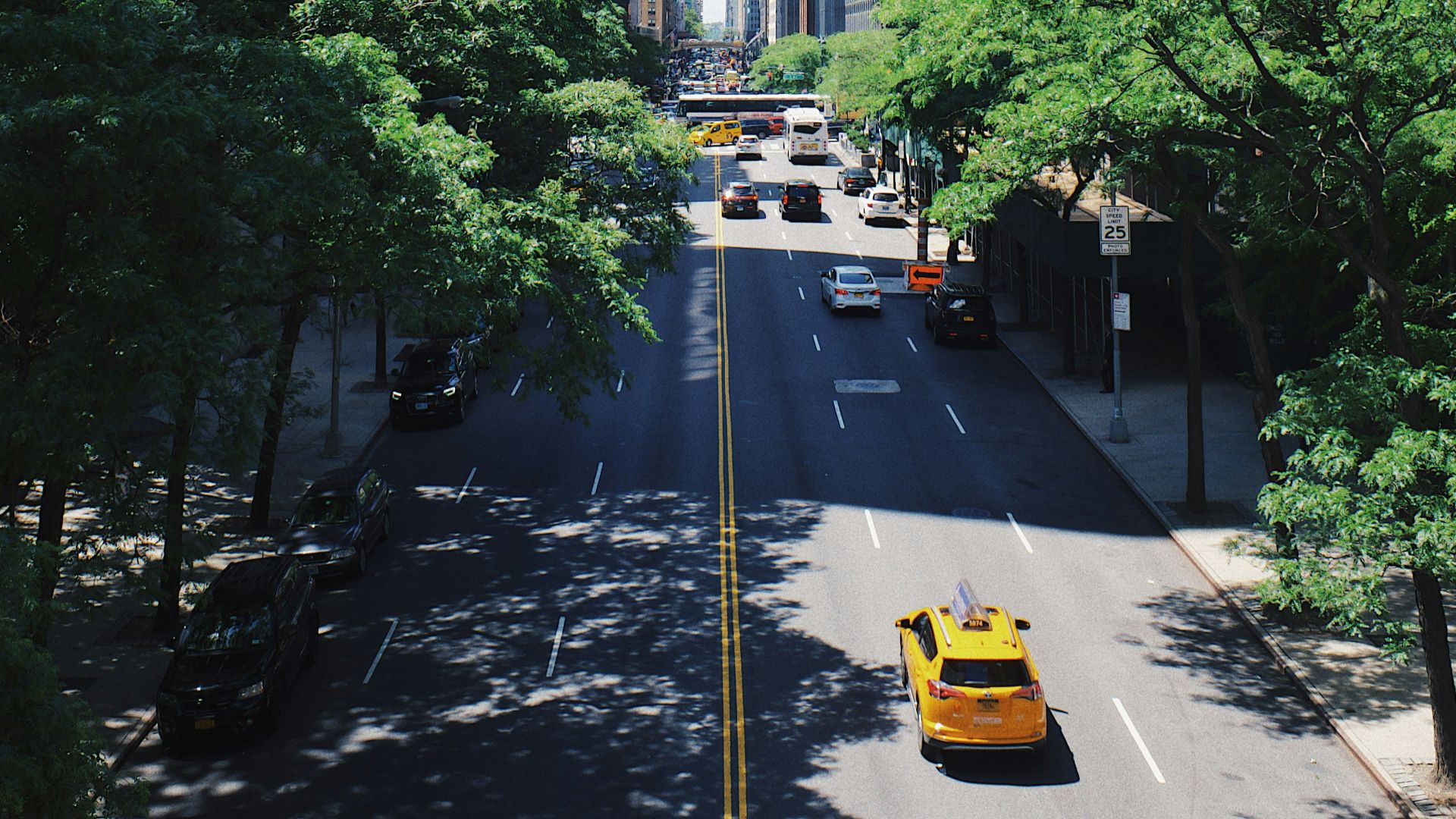 yellow car running on the street between the building during daytime