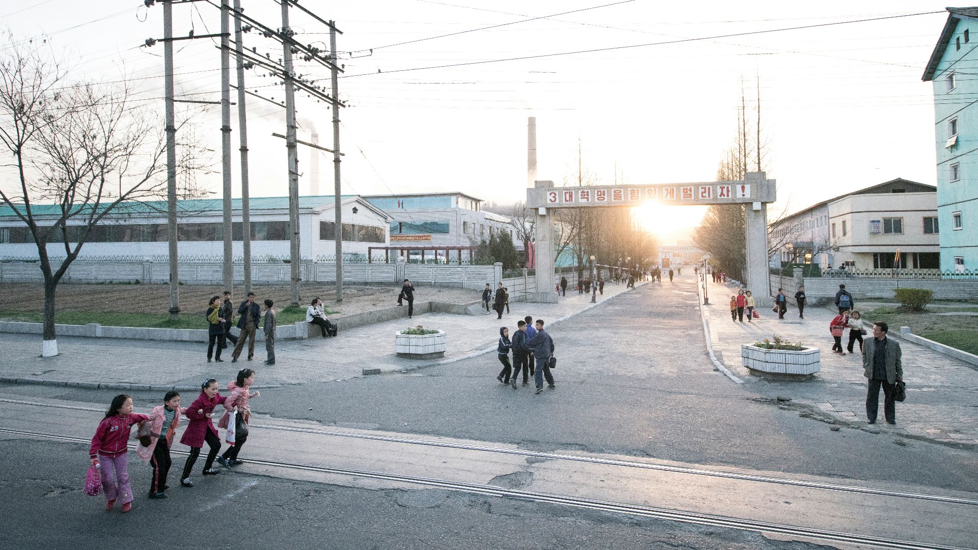 people walking, crossing, and standing at the streets near buildings