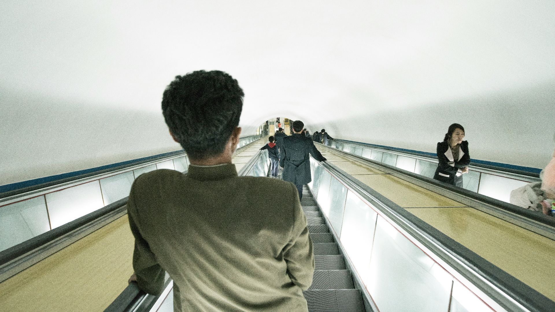man riding escalator