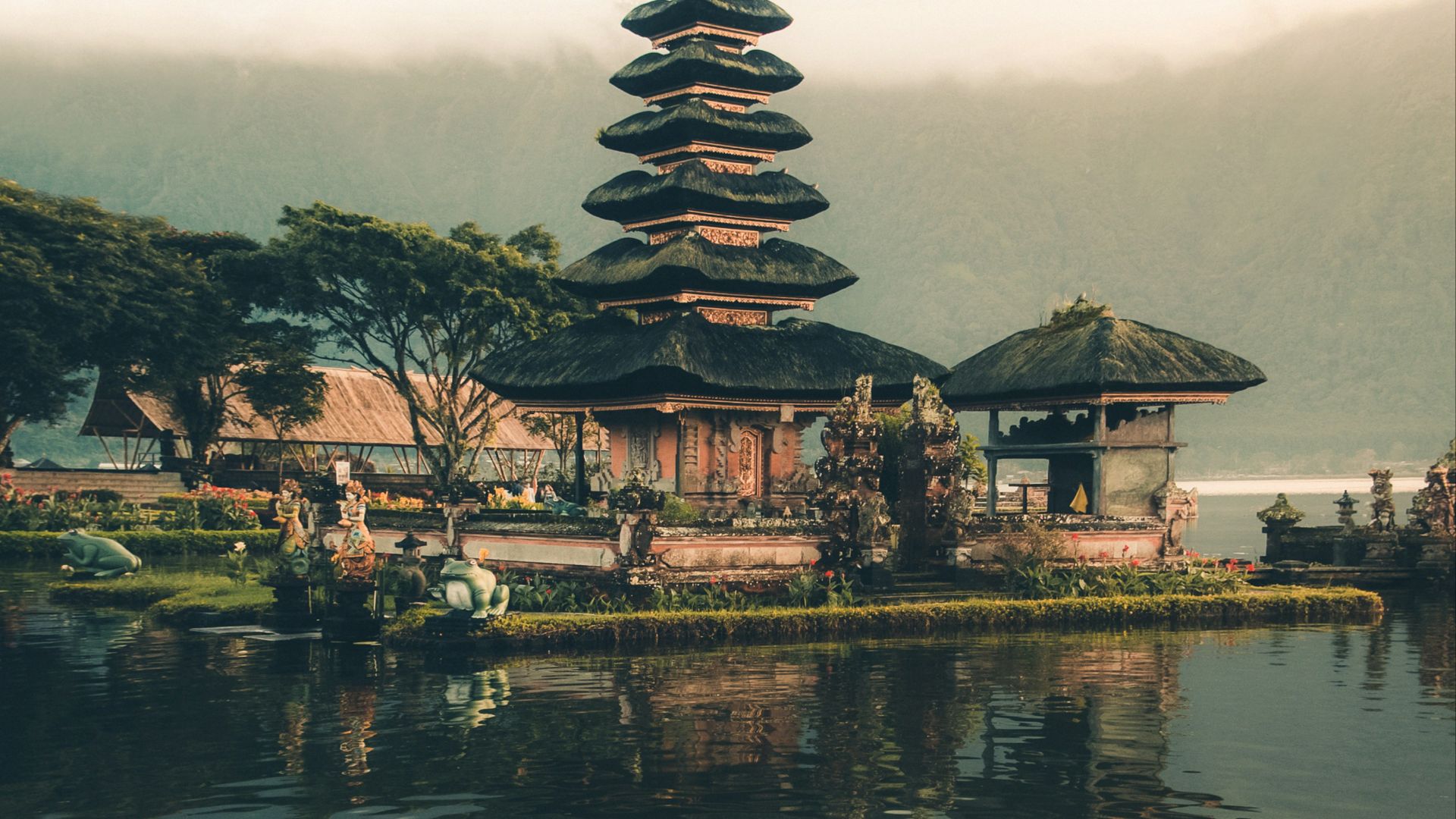 temple beside body of water and trees