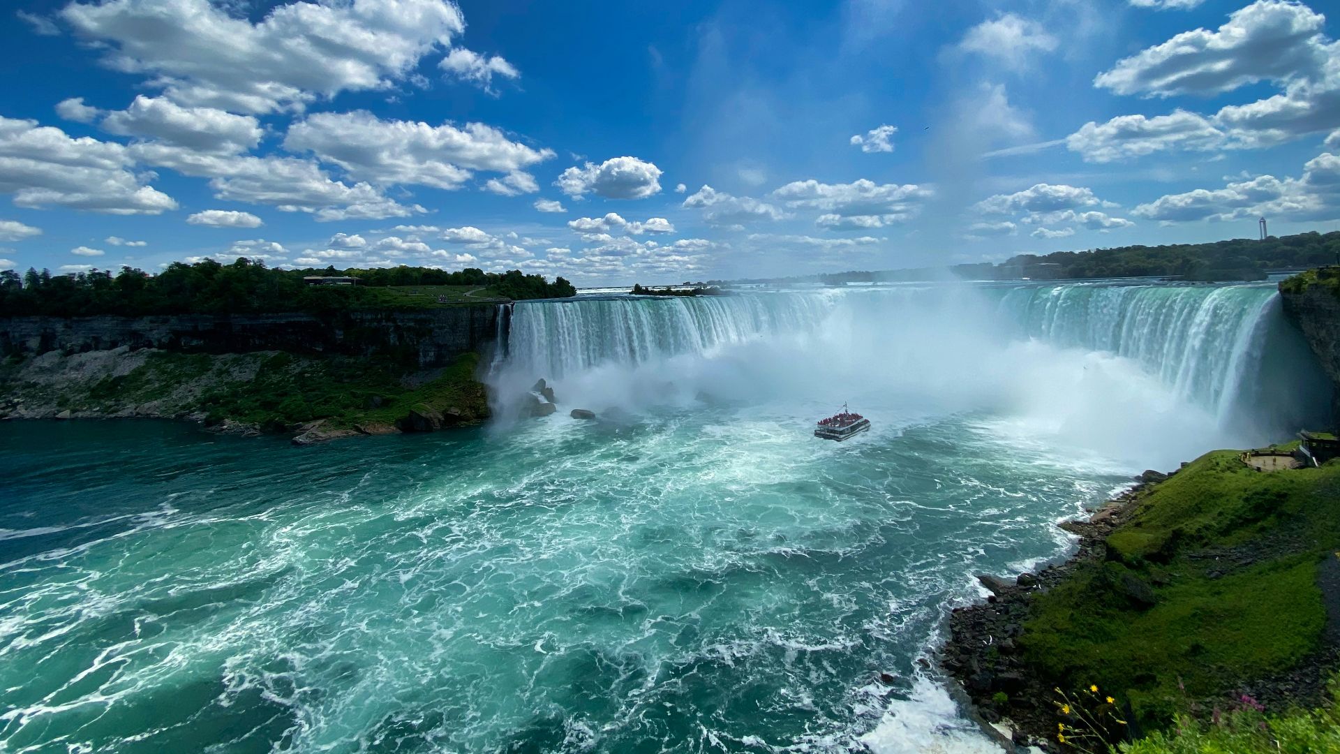 waterfalls under blue sky and white clouds during daytime