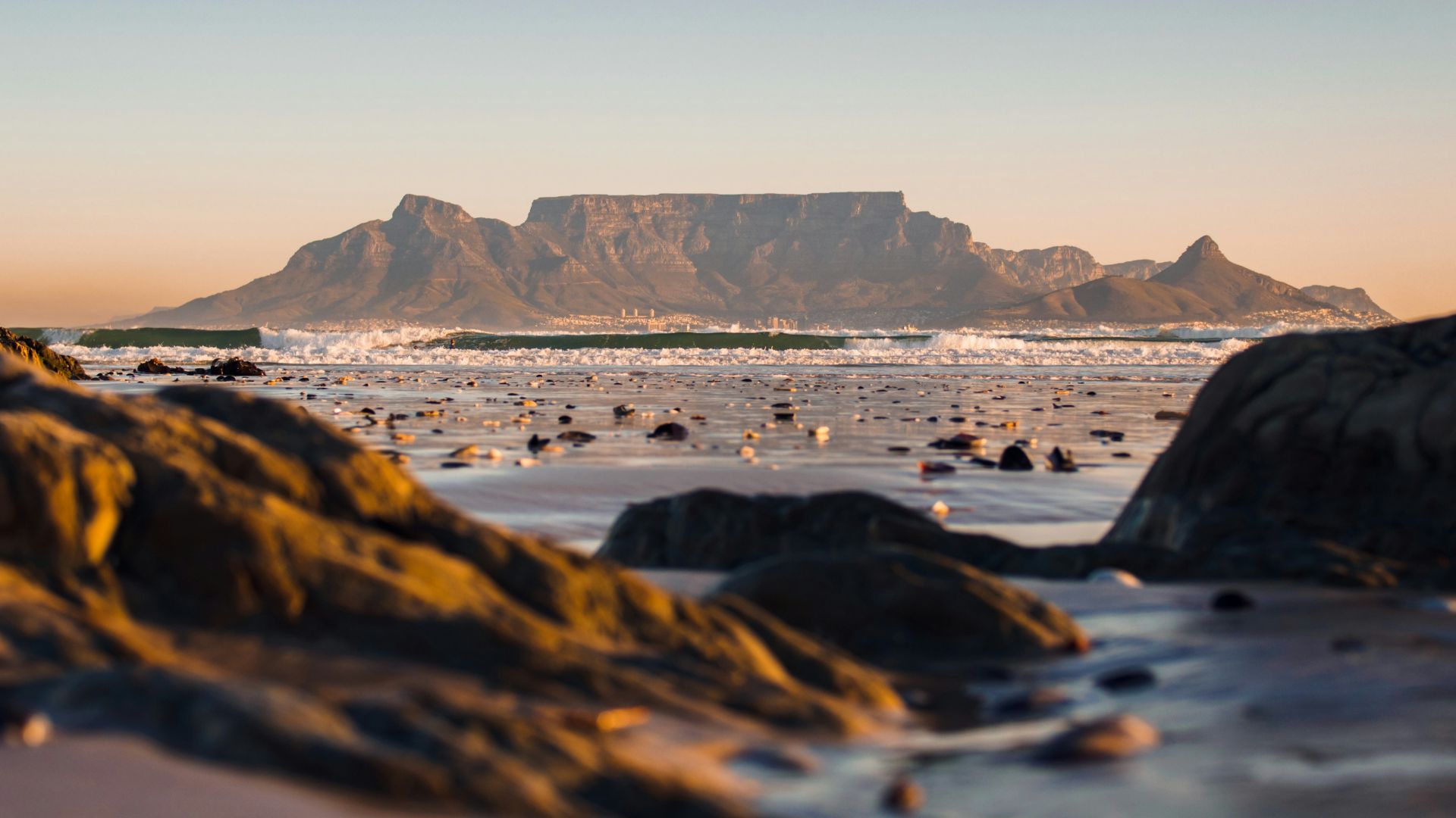 black rock formation on body of water during daytime