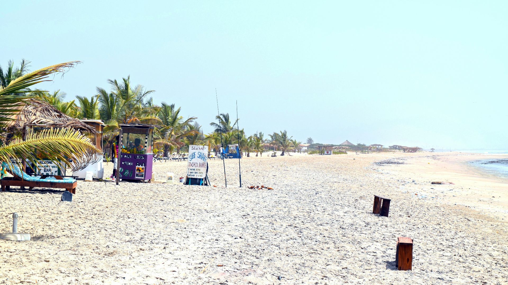 A sandy beach with a few chairs and umbrellas