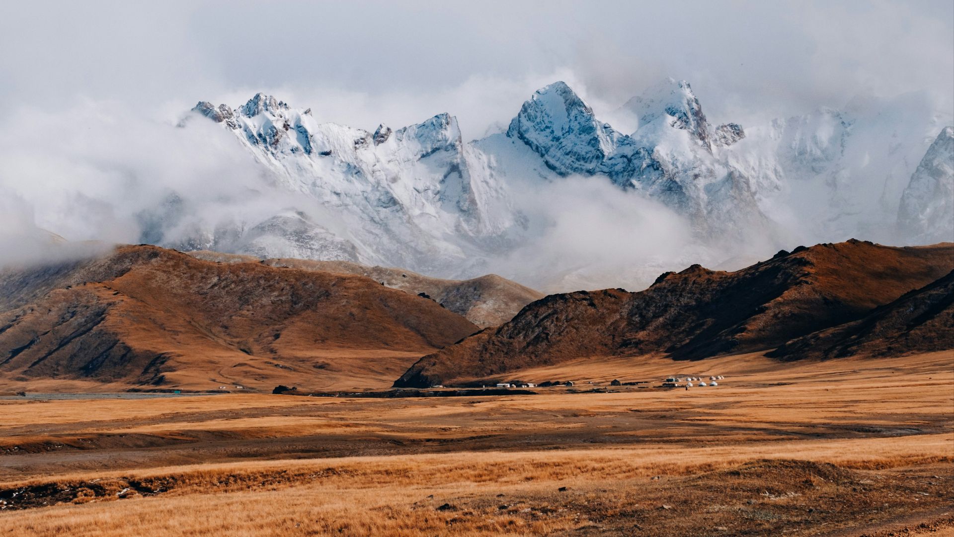 brown and white mountains under white clouds during daytime