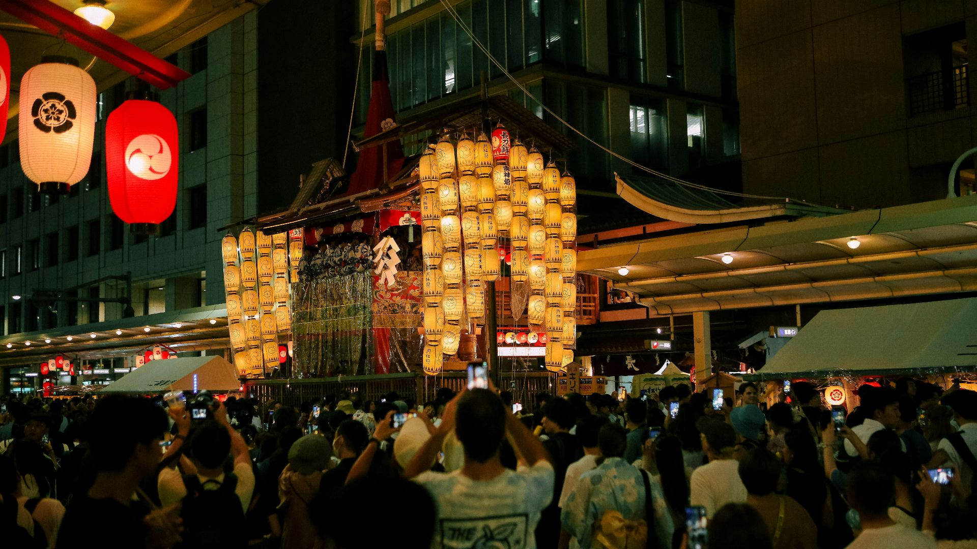 A crowd of people standing around a building at night
