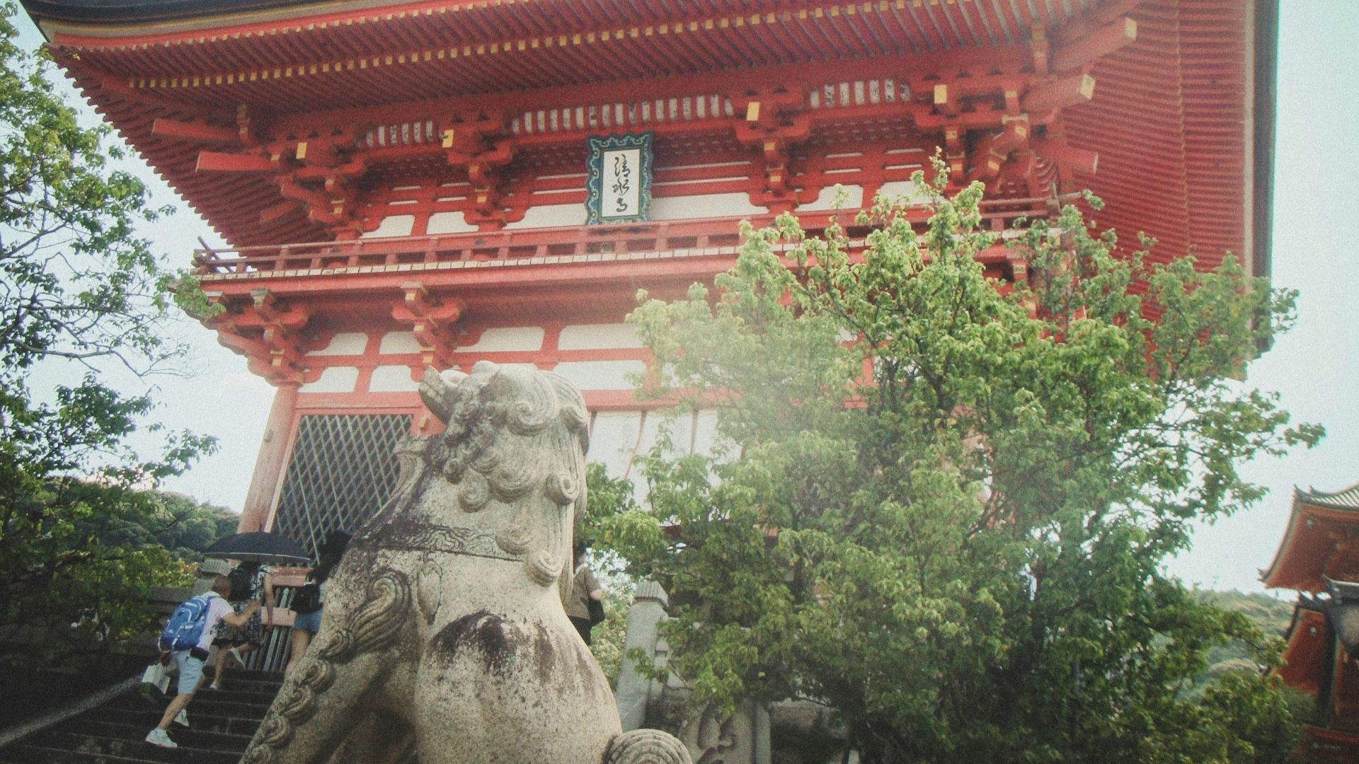 A tall red building with a statue in front of it