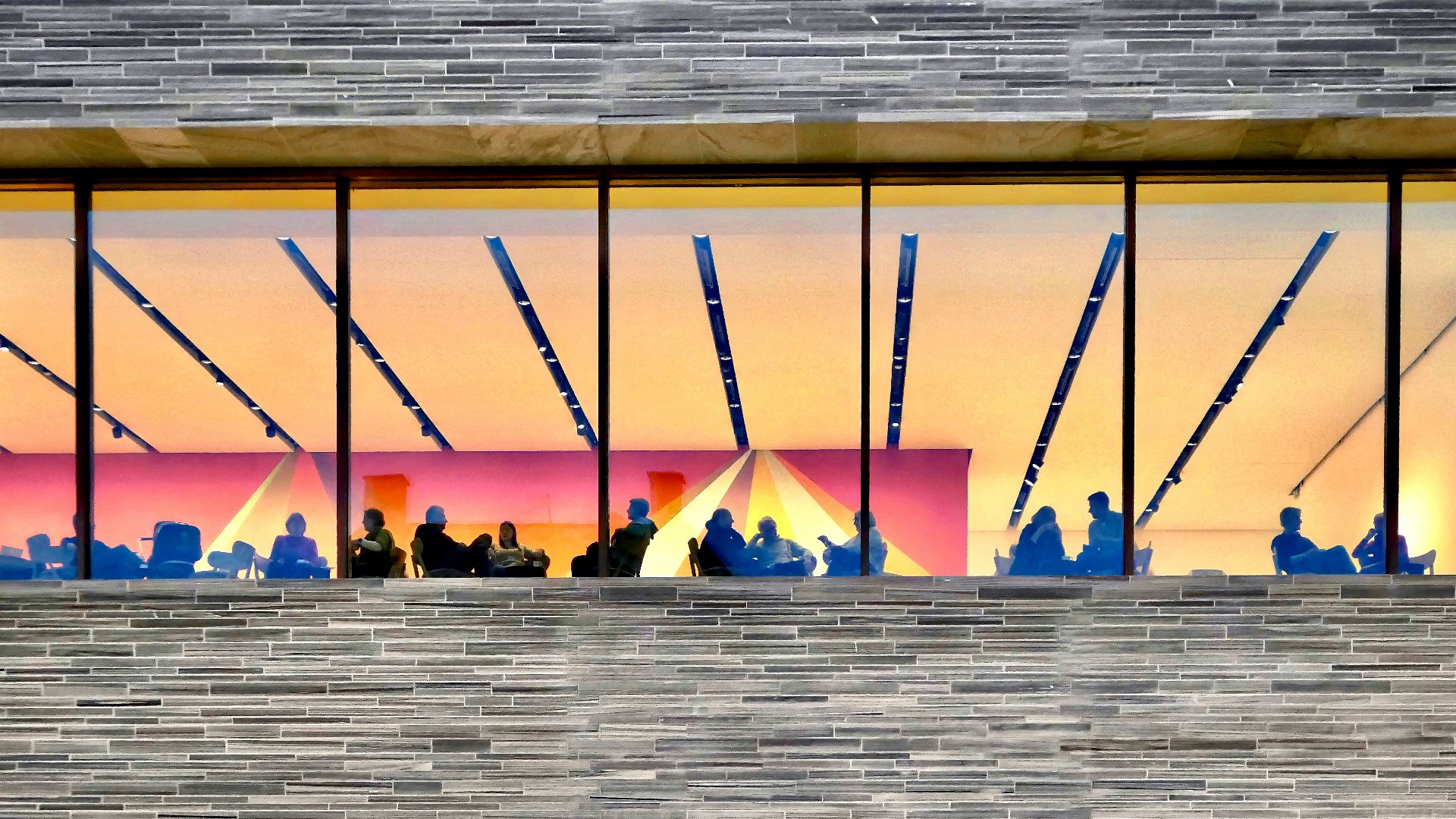 a person sitting on a bench in front of a window